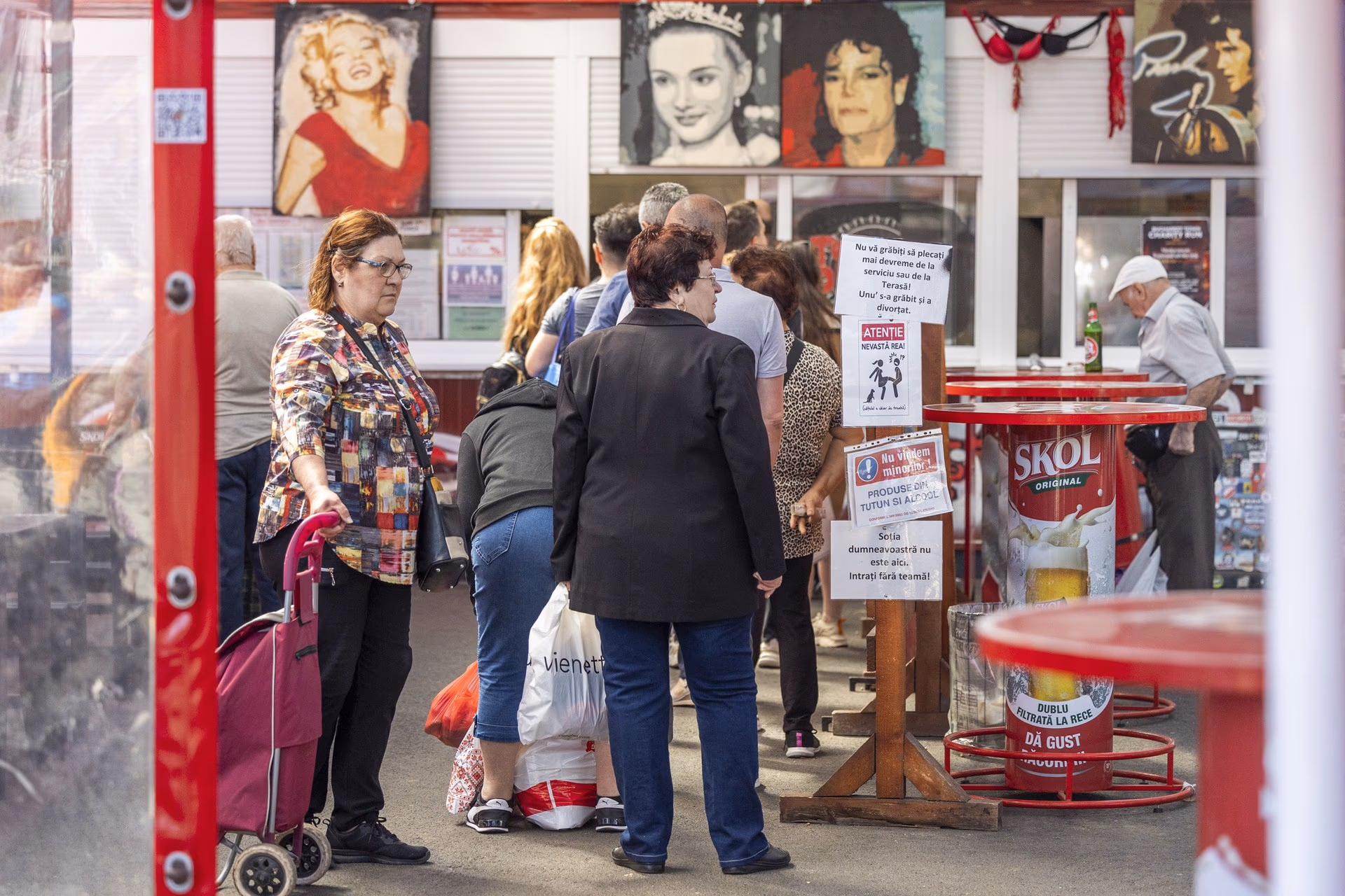 Coadă festivă la Terasa Obor, cu portretele pop ale lui Marilyn Monroe, James Dean, Michael Jackson și Freddie Mercury pe pereți.