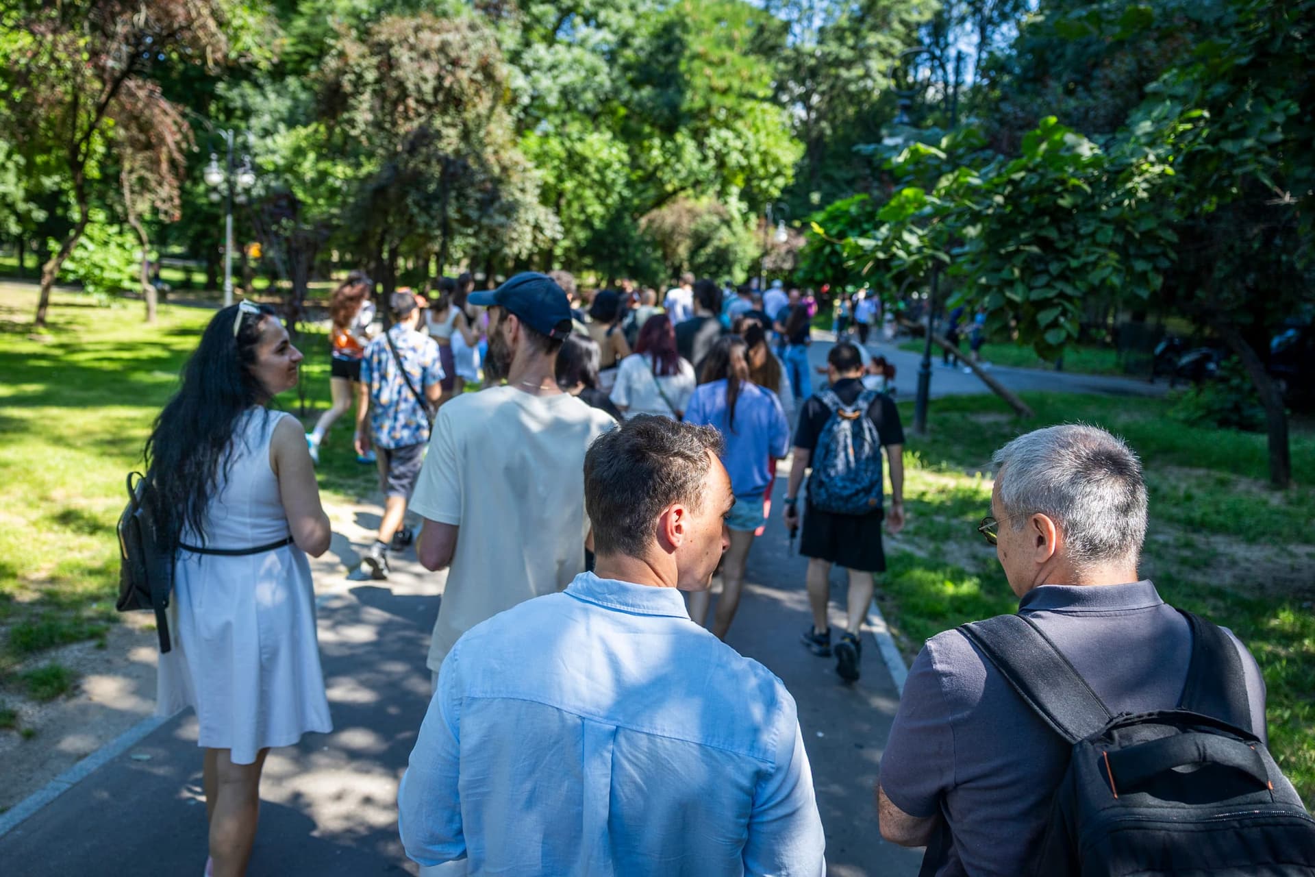 A csoport egy Cișmigiu-allén sétálva, hosszú sorba rendezve a vén fák árnyéka alatt