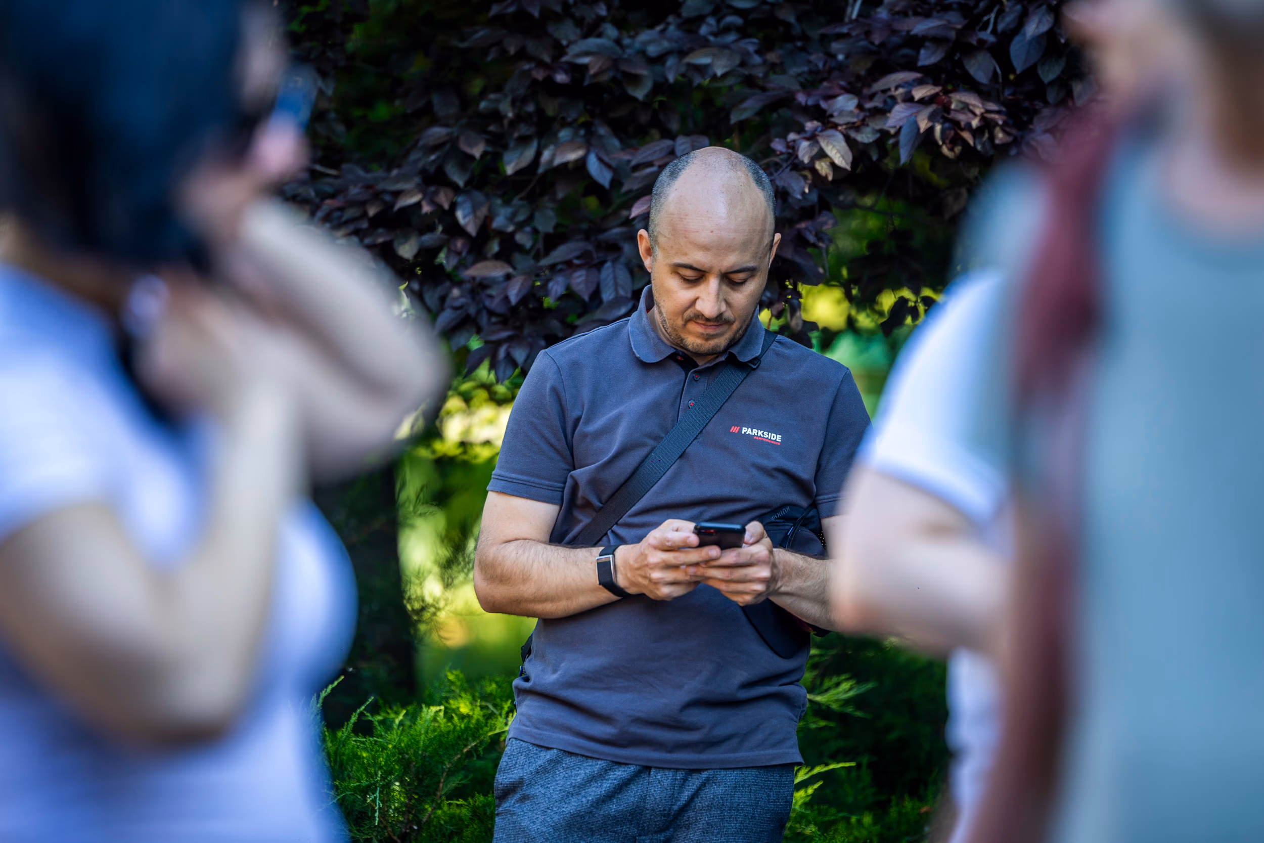 A TURA x Ideas Chat! participant checks his phone, in a Parkside polo