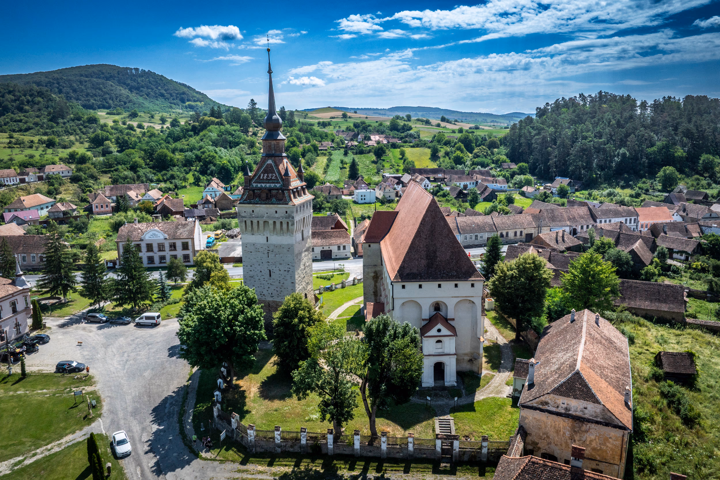 Biserica gotică și clopotnița din Saschiz — case săsești în jur, turnul de patruzeci de metri