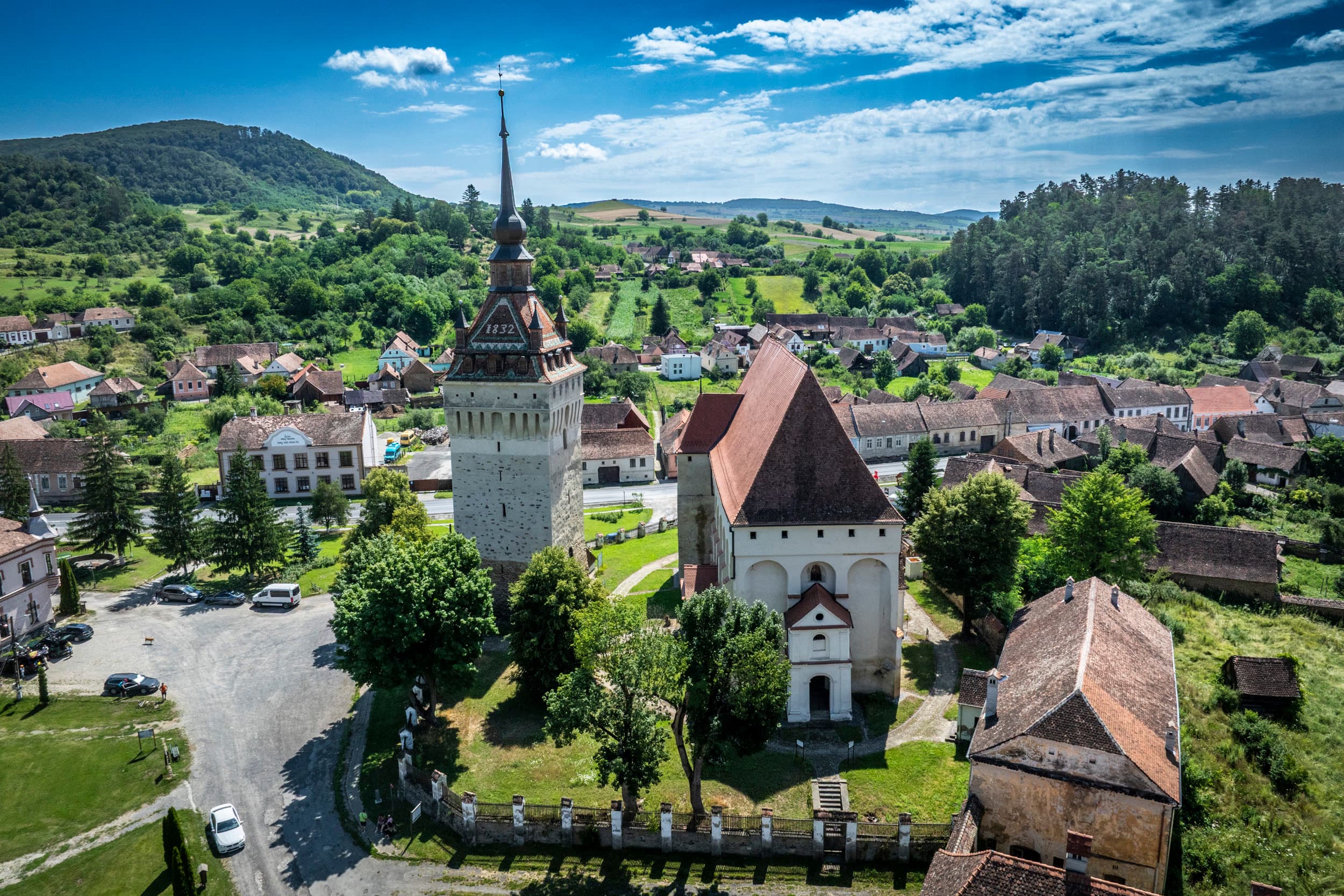 Biserica gotică și clopotnița din Saschiz — case săsești în jur, turnul de patruzeci de metri