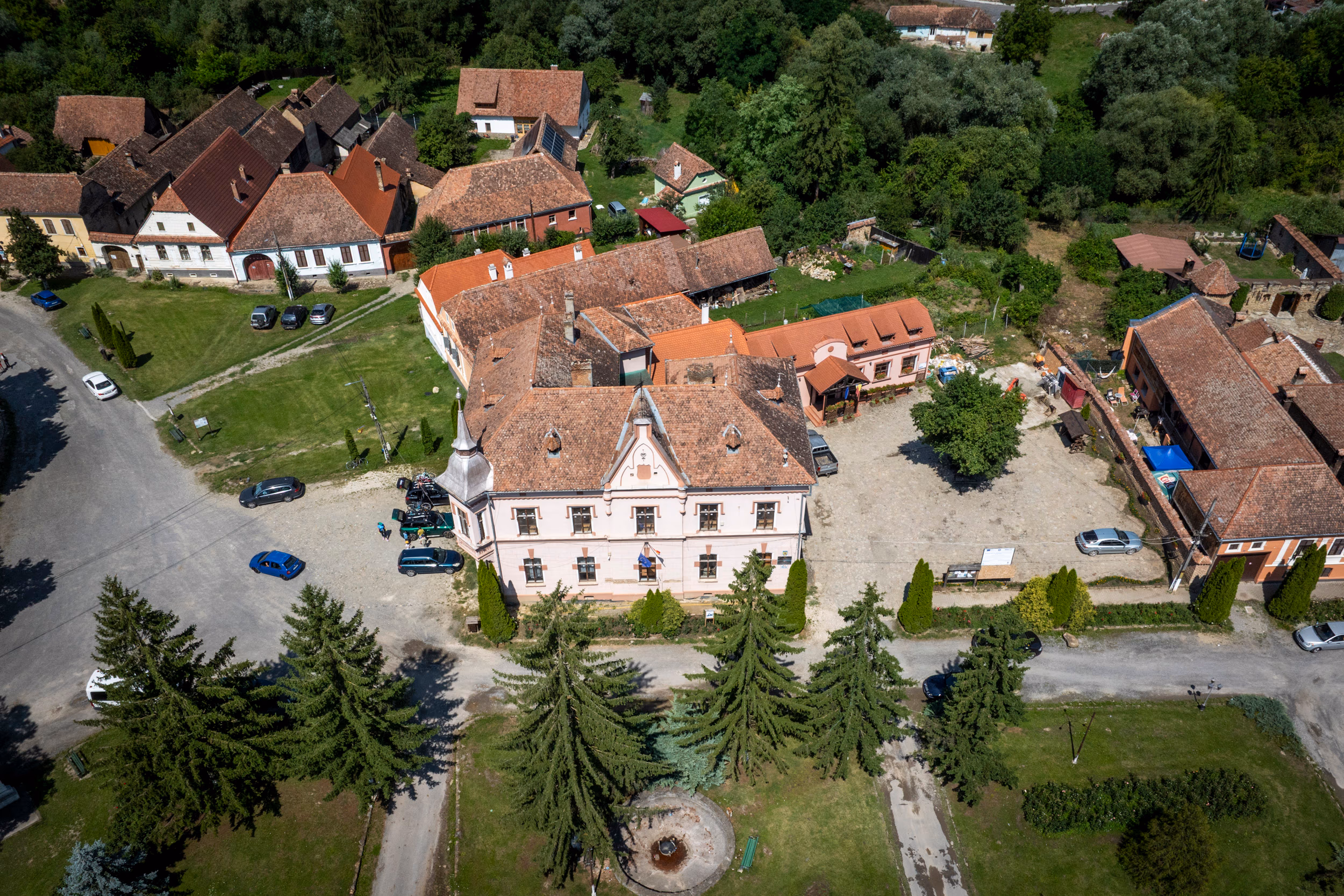 Casă săsească restaurată — fronton clasic, curte gospodărească, una dintre pensiunile din sat