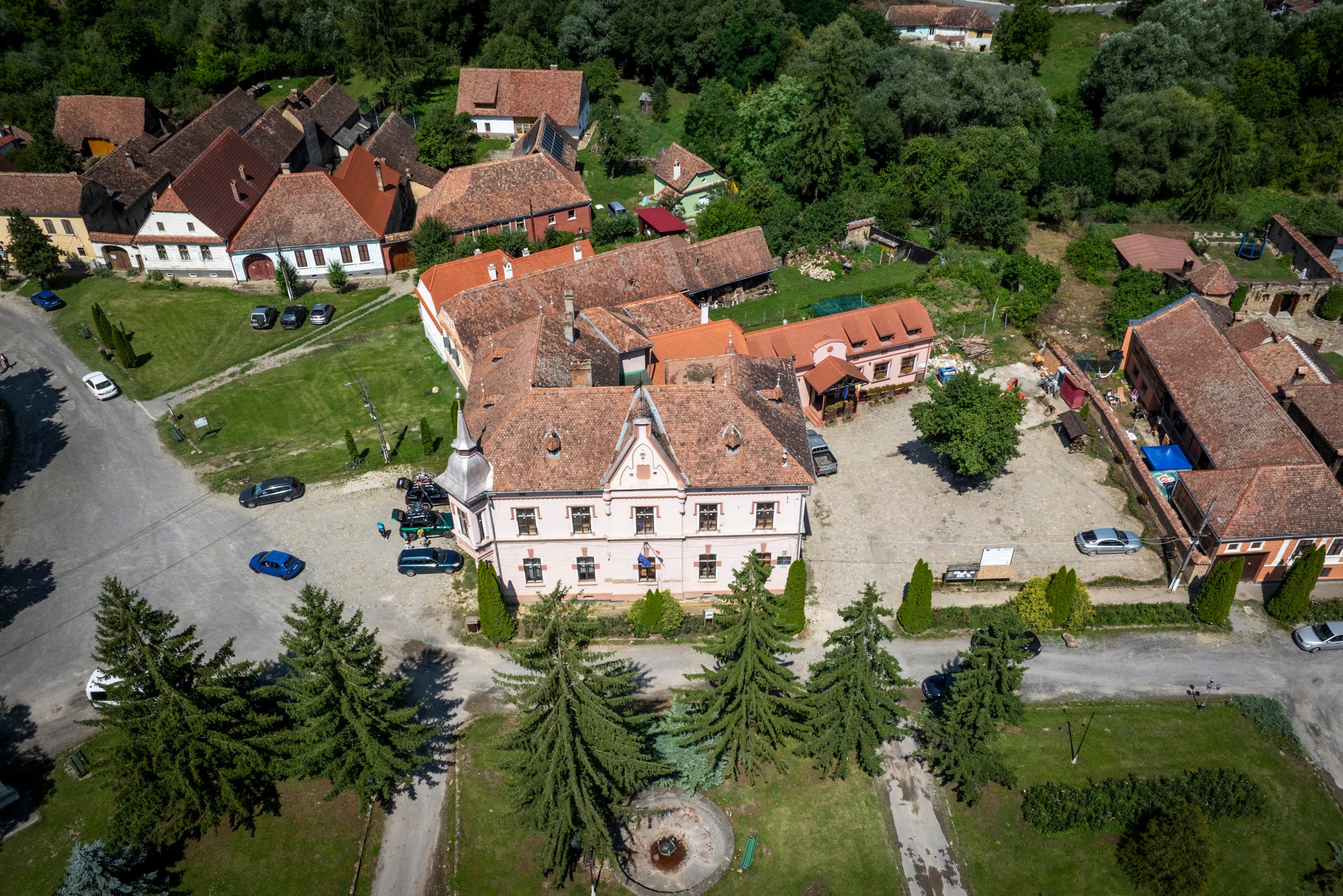 Casă săsească restaurată — fronton clasic, curte gospodărească, una dintre pensiunile din sat