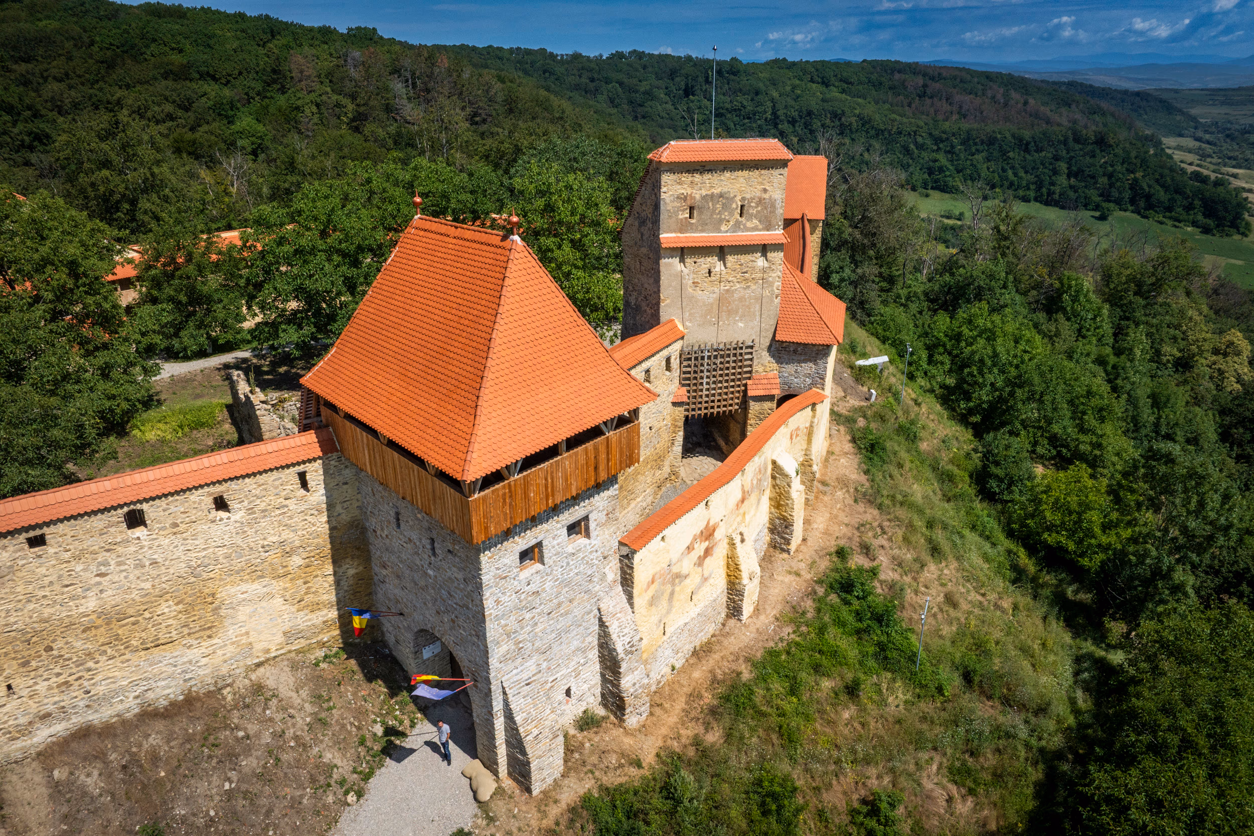 Cetatea Țărănească — turnul de intrare cu drapelul român, restaurat, vizitatori la poartă