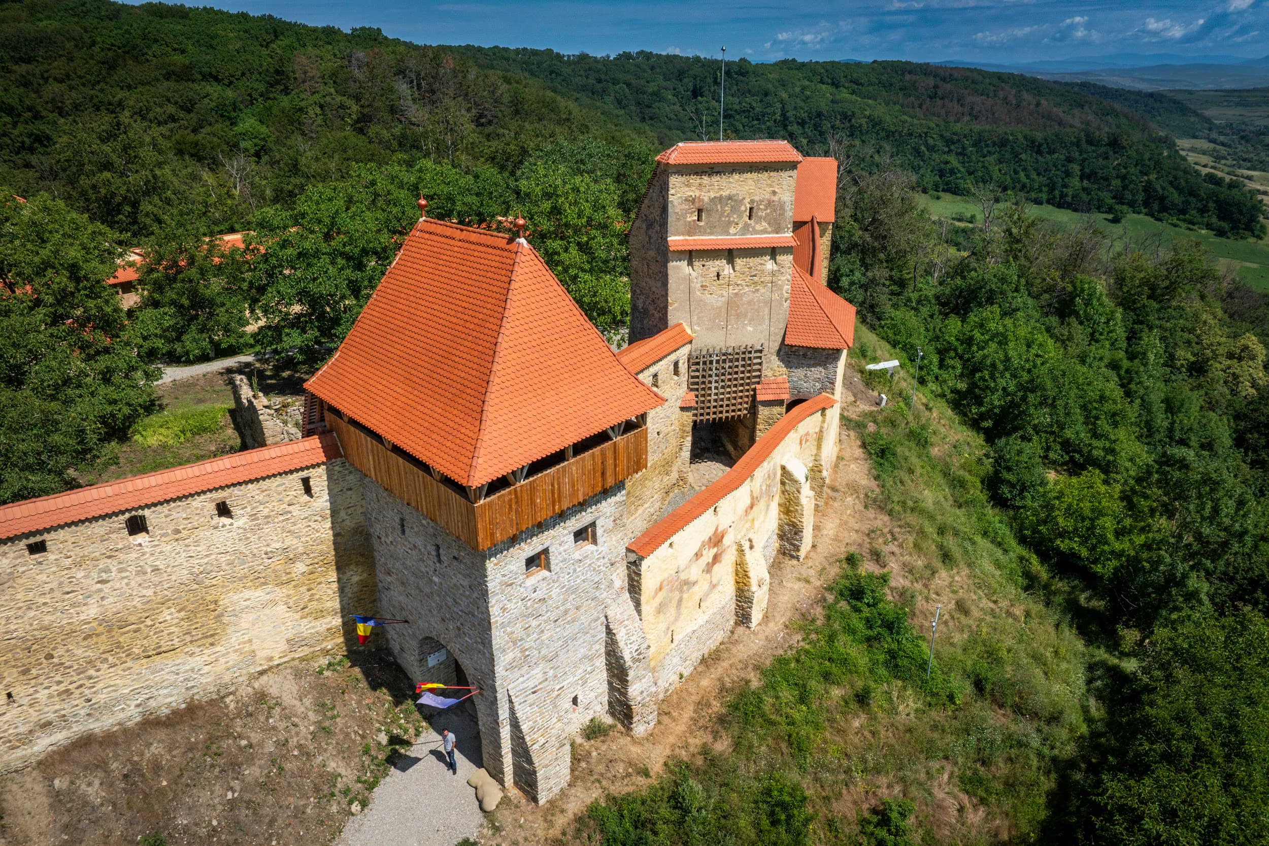 Cetatea Țărănească — turnul de intrare cu drapelul român, restaurat, vizitatori la poartă