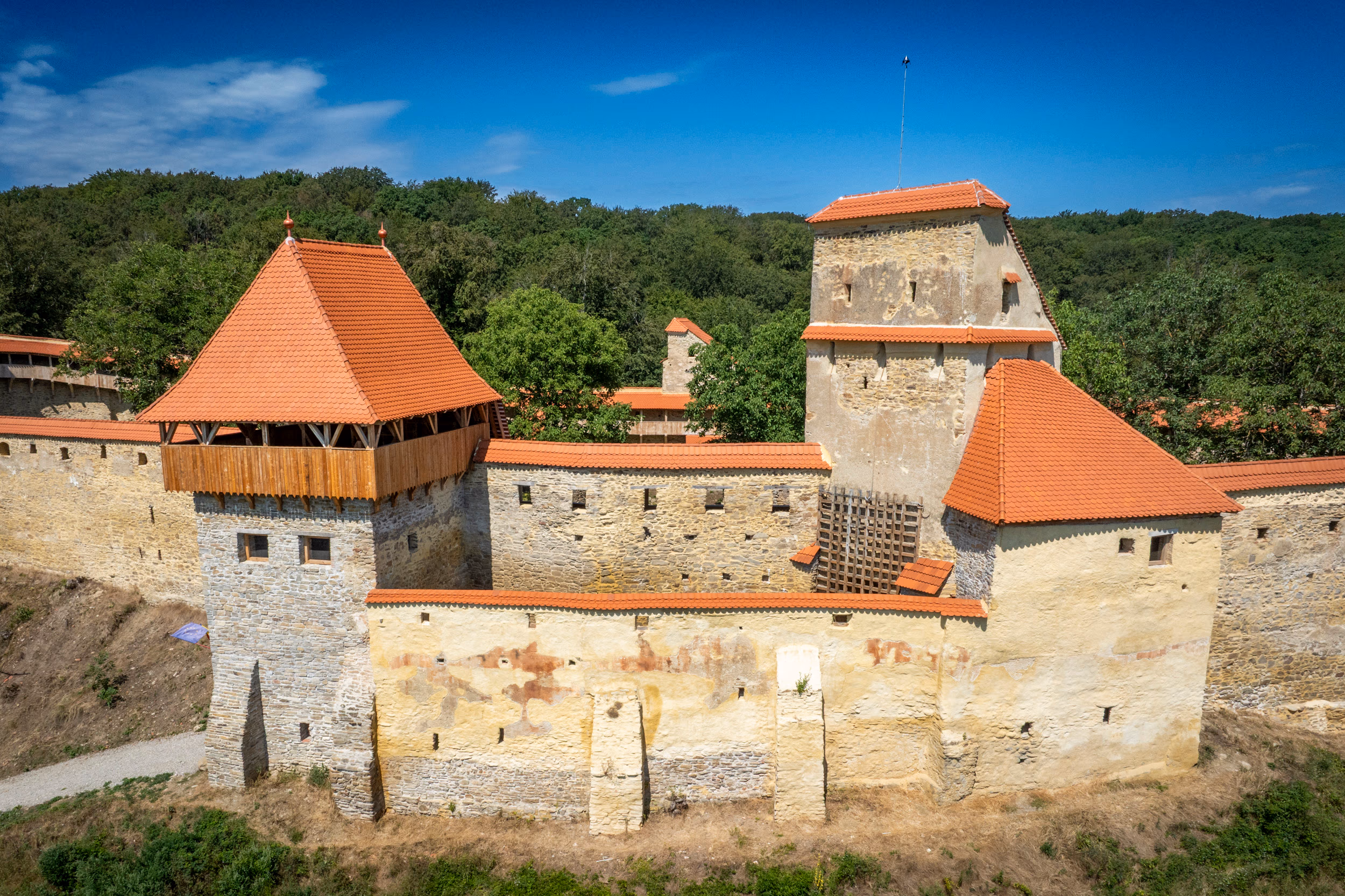 Cetatea Țărănească — detaliu al turnului-poartă și zidului de incintă restaurat, ziduri galben-deschis