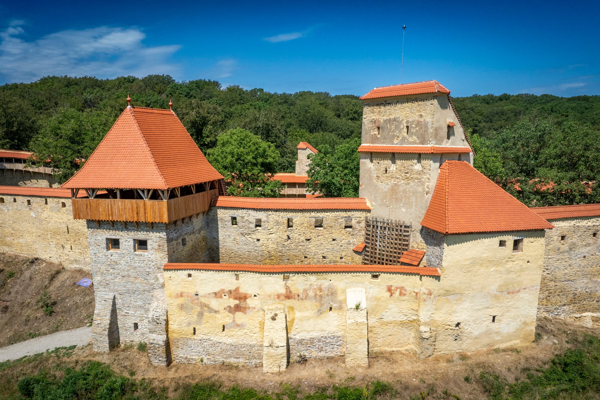 Cetatea Țărănească — detaliu al turnului-poartă și zidului de incintă restaurat, ziduri galben-deschis