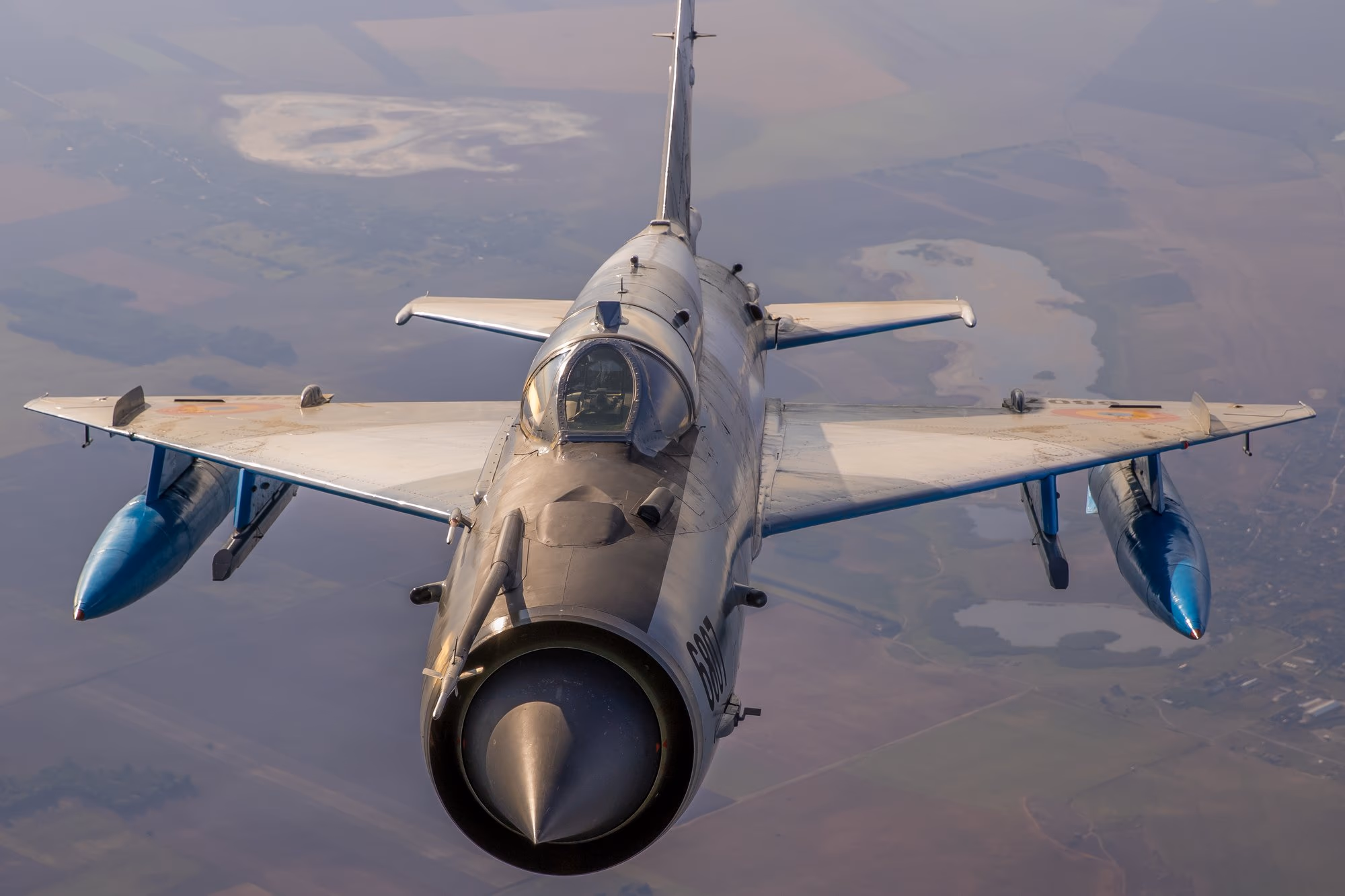 MiG-21 LanceR repülés közben — szembe nézet a mezőgazdasági táj fölött