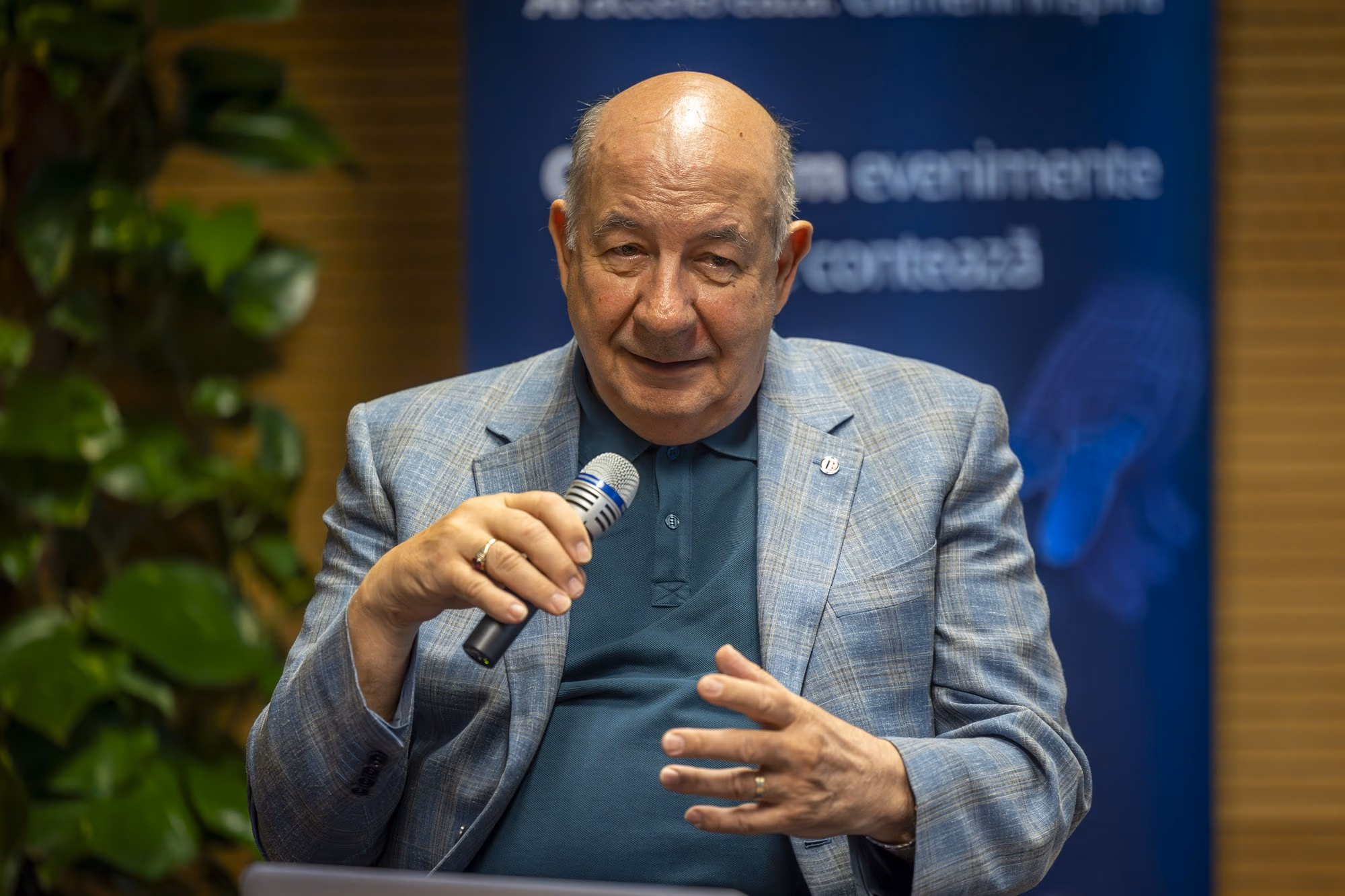 Radu Ghețea, former president of CEC Bank, older man, speaking into the microphone, navy polo under light blue blazer