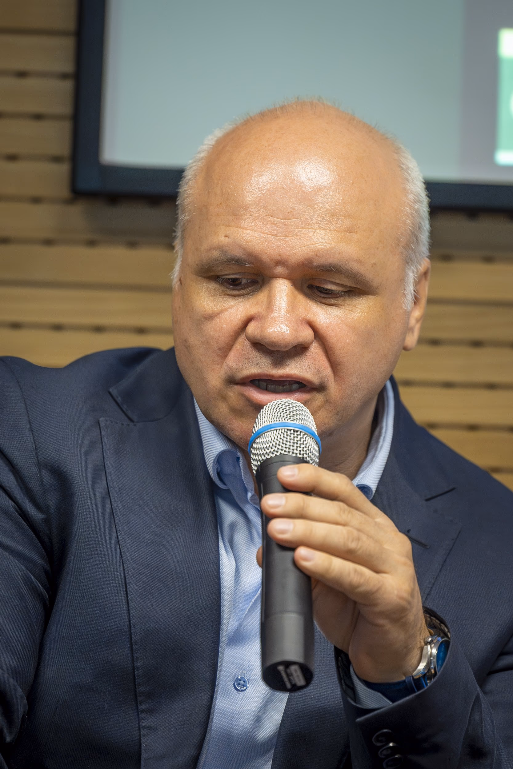 Sorin Faur, founder of the Academia de HR, speaking into the microphone with a wide gesture, navy suit