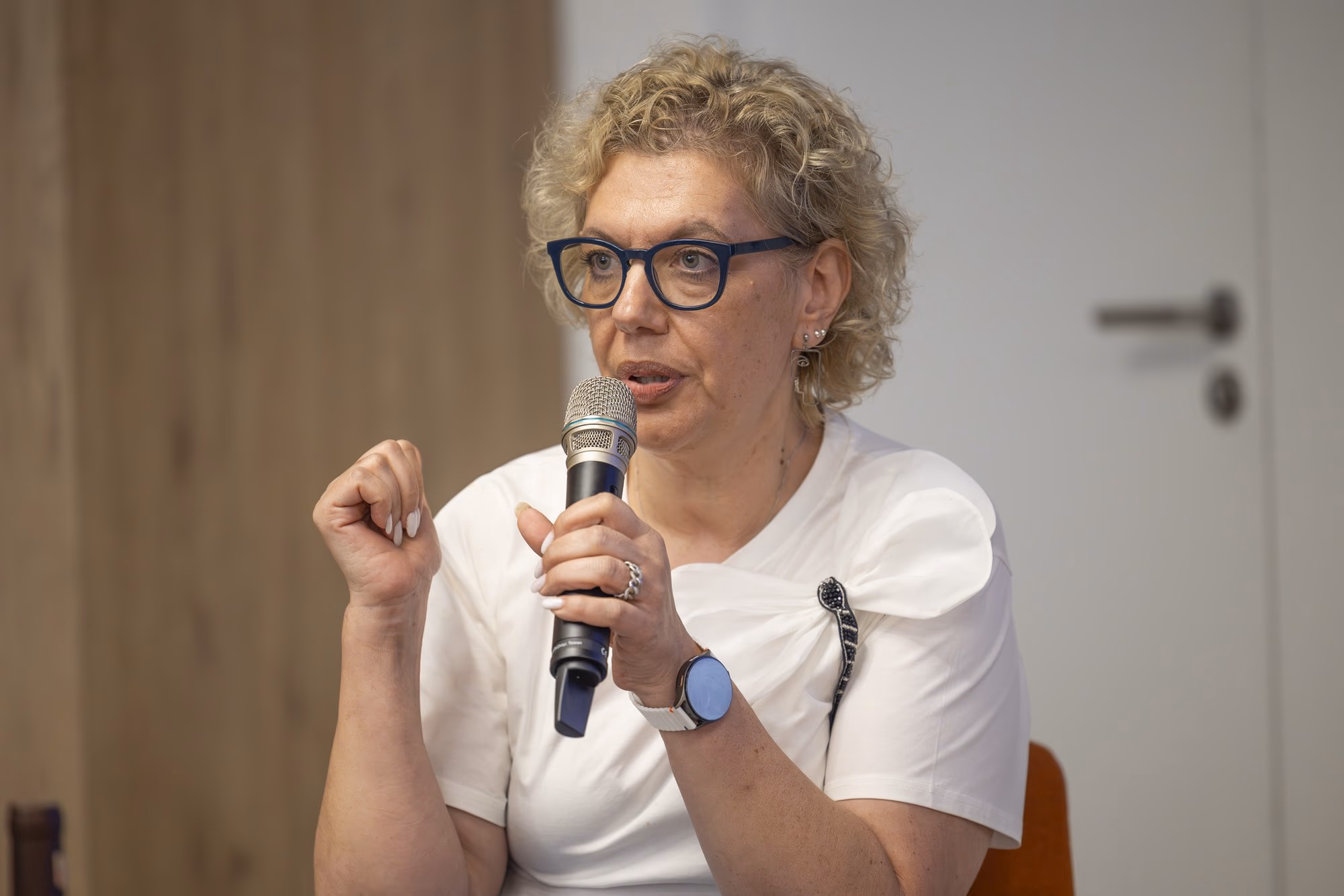 Flavia Voinea, manager of Radio București FM, with blue glasses and a printed skirt in panel 4.