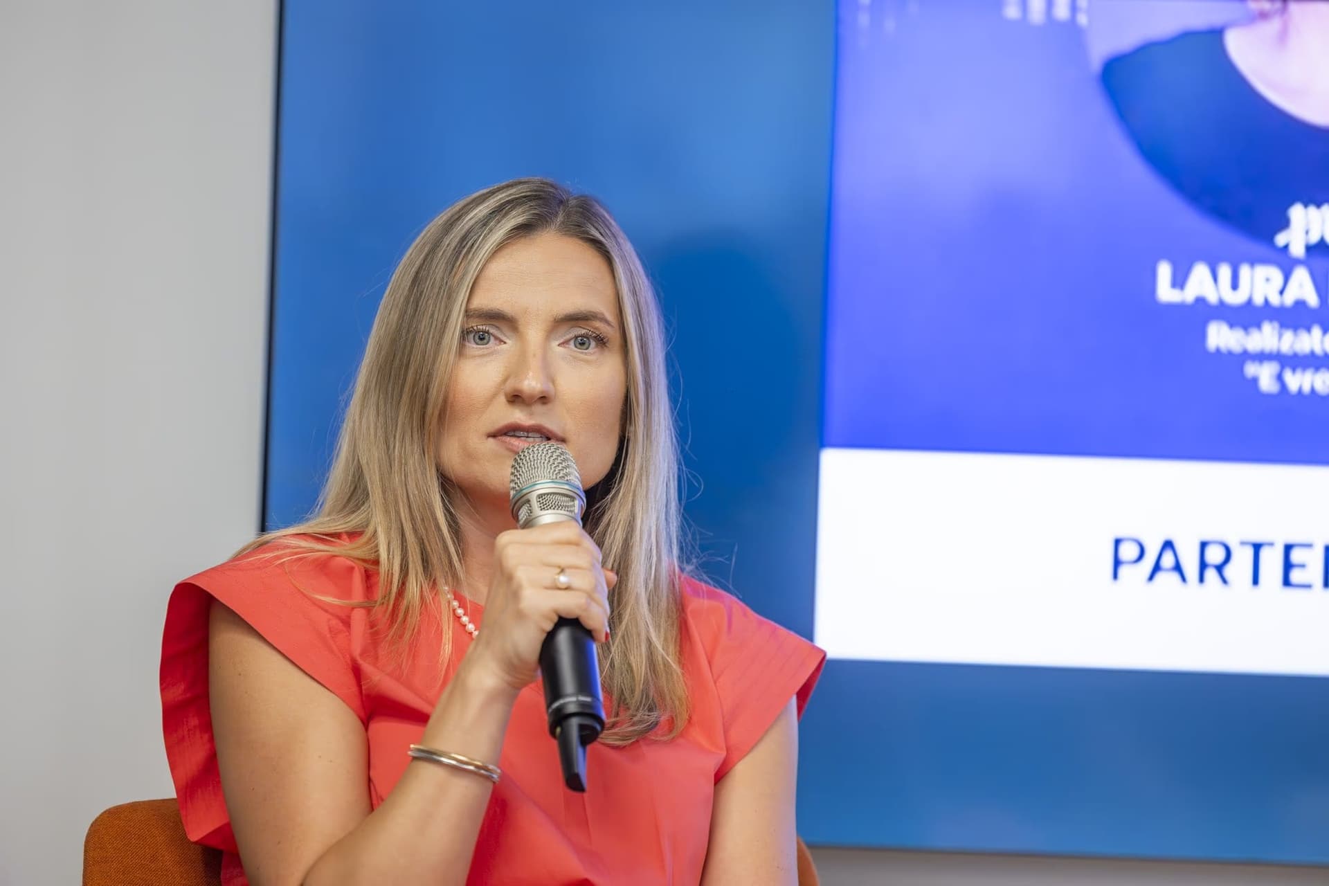 Manuela Ciugudean a mikrofonnal közepes plánban.
