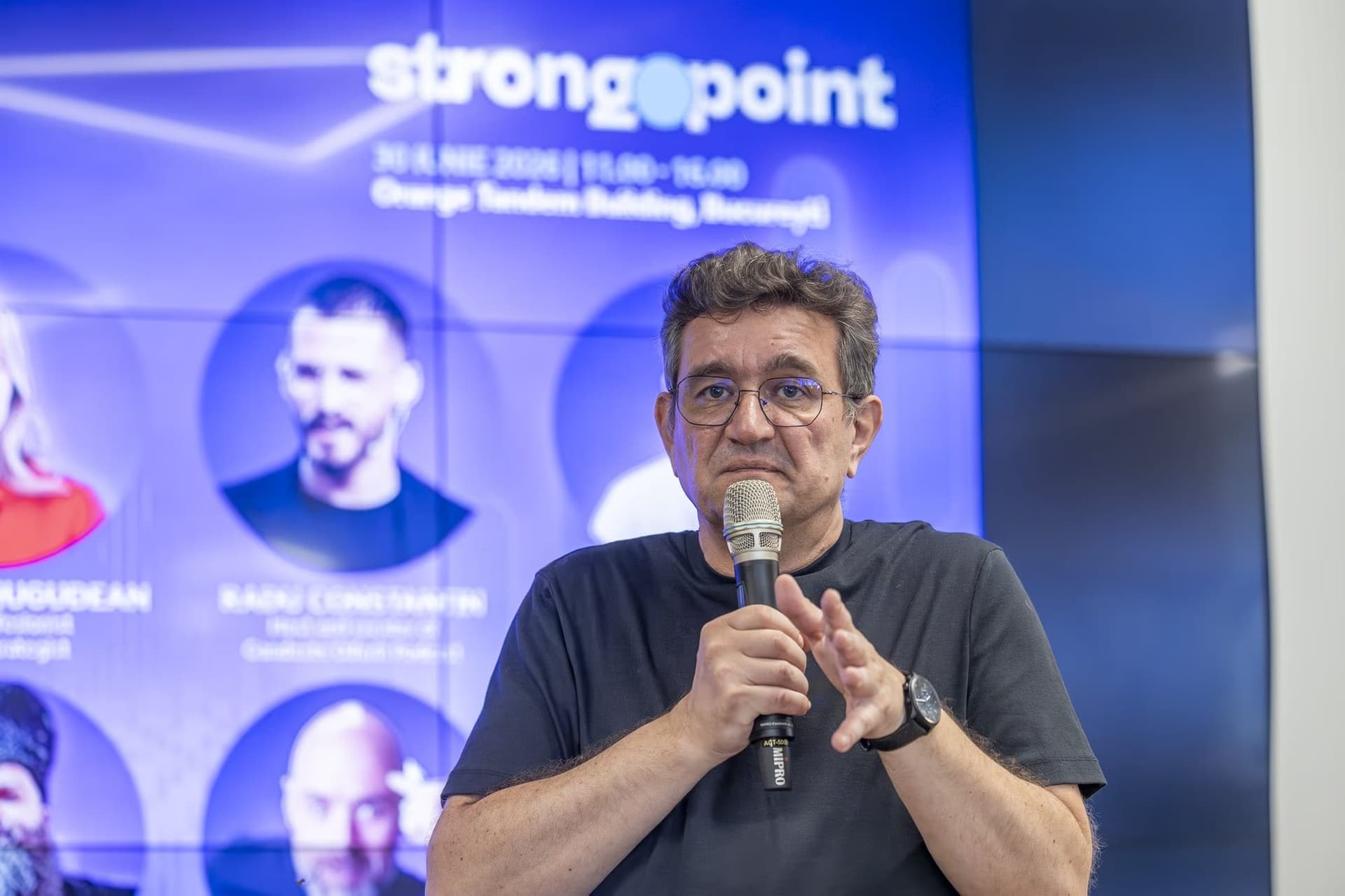 Chinezu a mikrofonnál, az 1. panelben — a moderátor, aki stand-up színészként vezet.