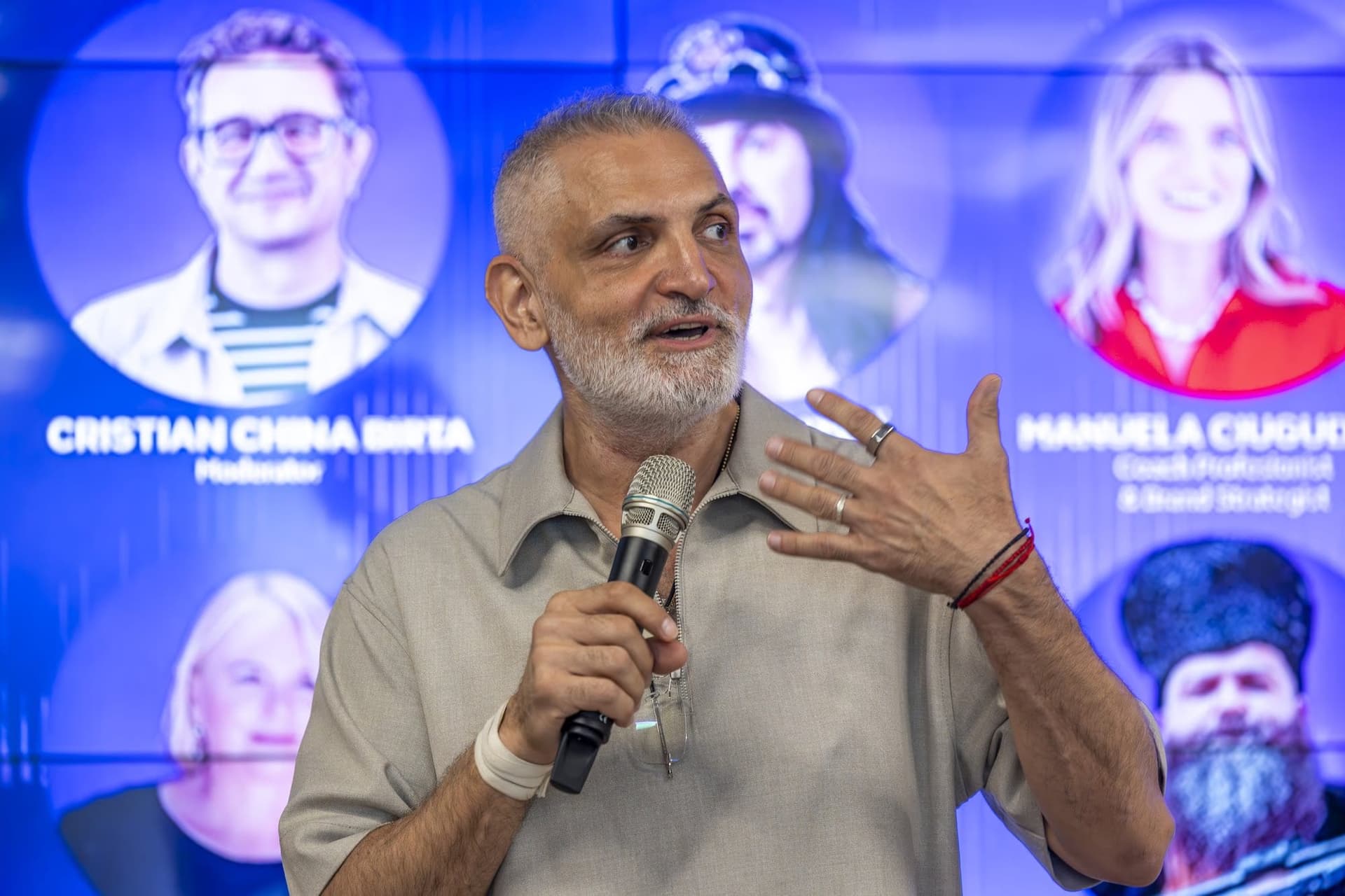 Damian Drăghici a mikrofonnál a 2. panelben, a plakát fotójával a hátterében.
