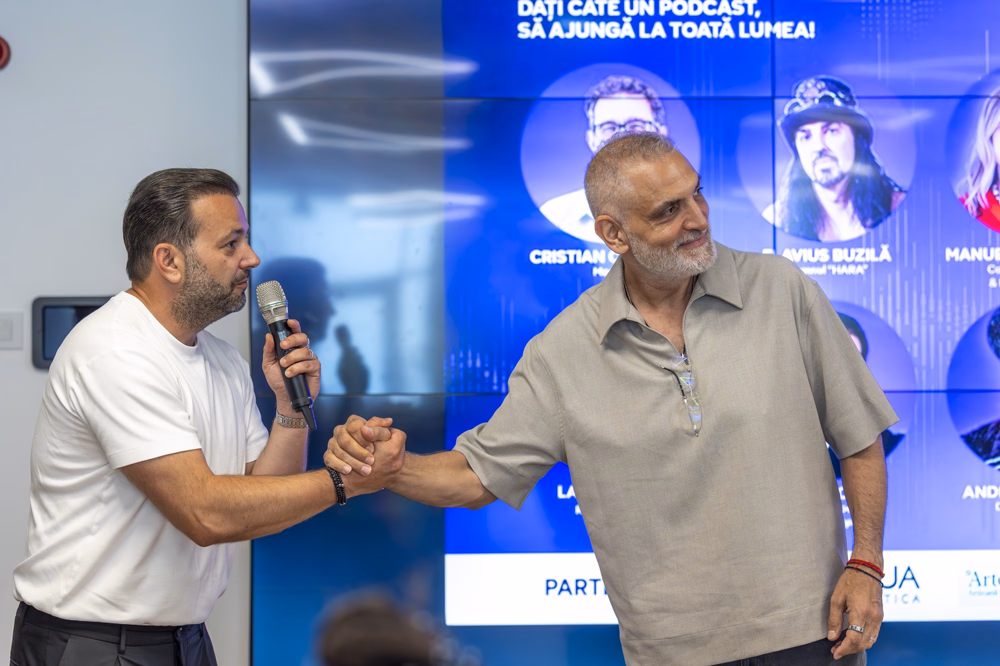Damian Drăghici (right) walks onto the stage next to Chinezu, hand extended to the audience.