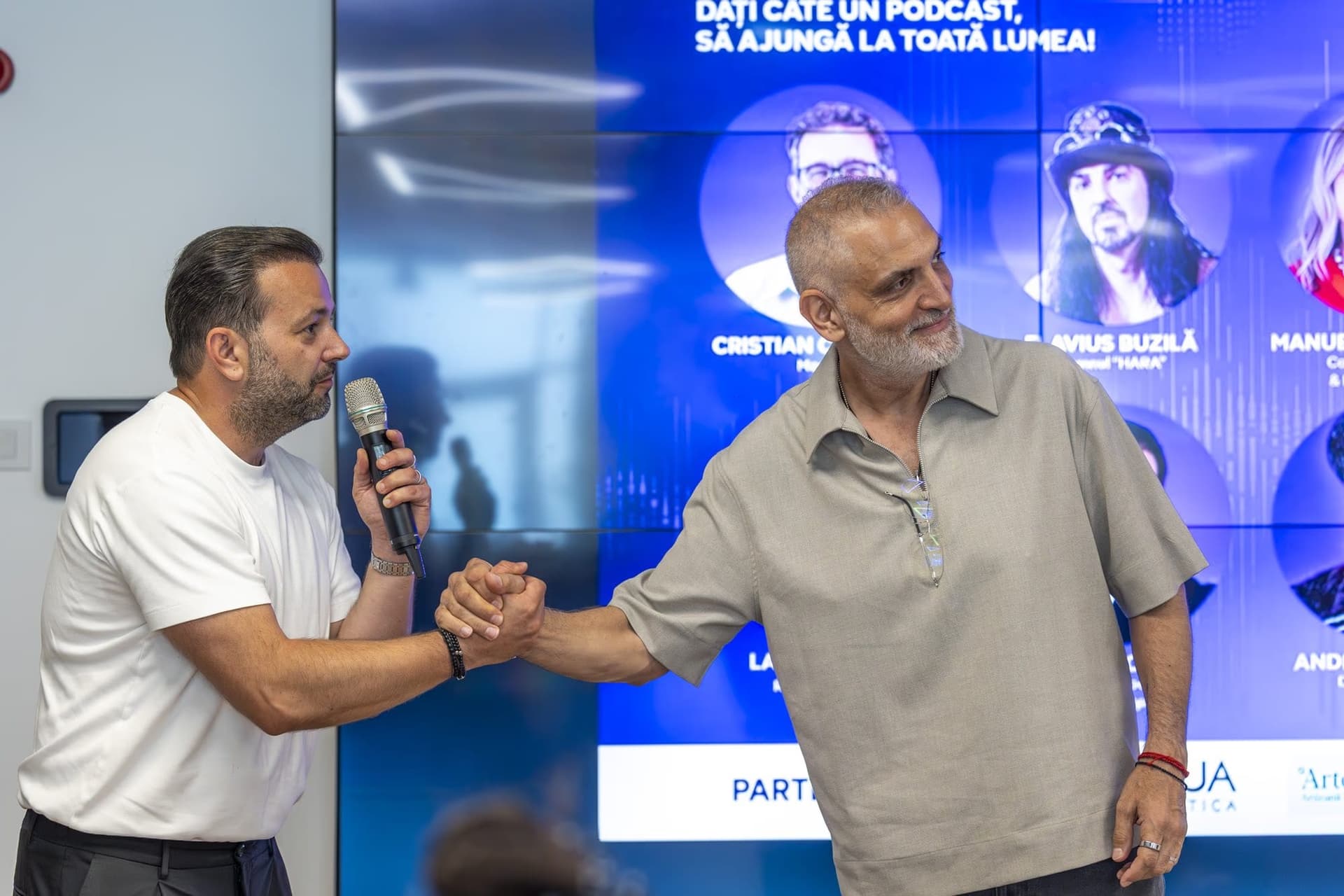 Damian Drăghici (jobbra) belép a színpadra Chinezu mellett, kézét a közönség felé nyújtva.