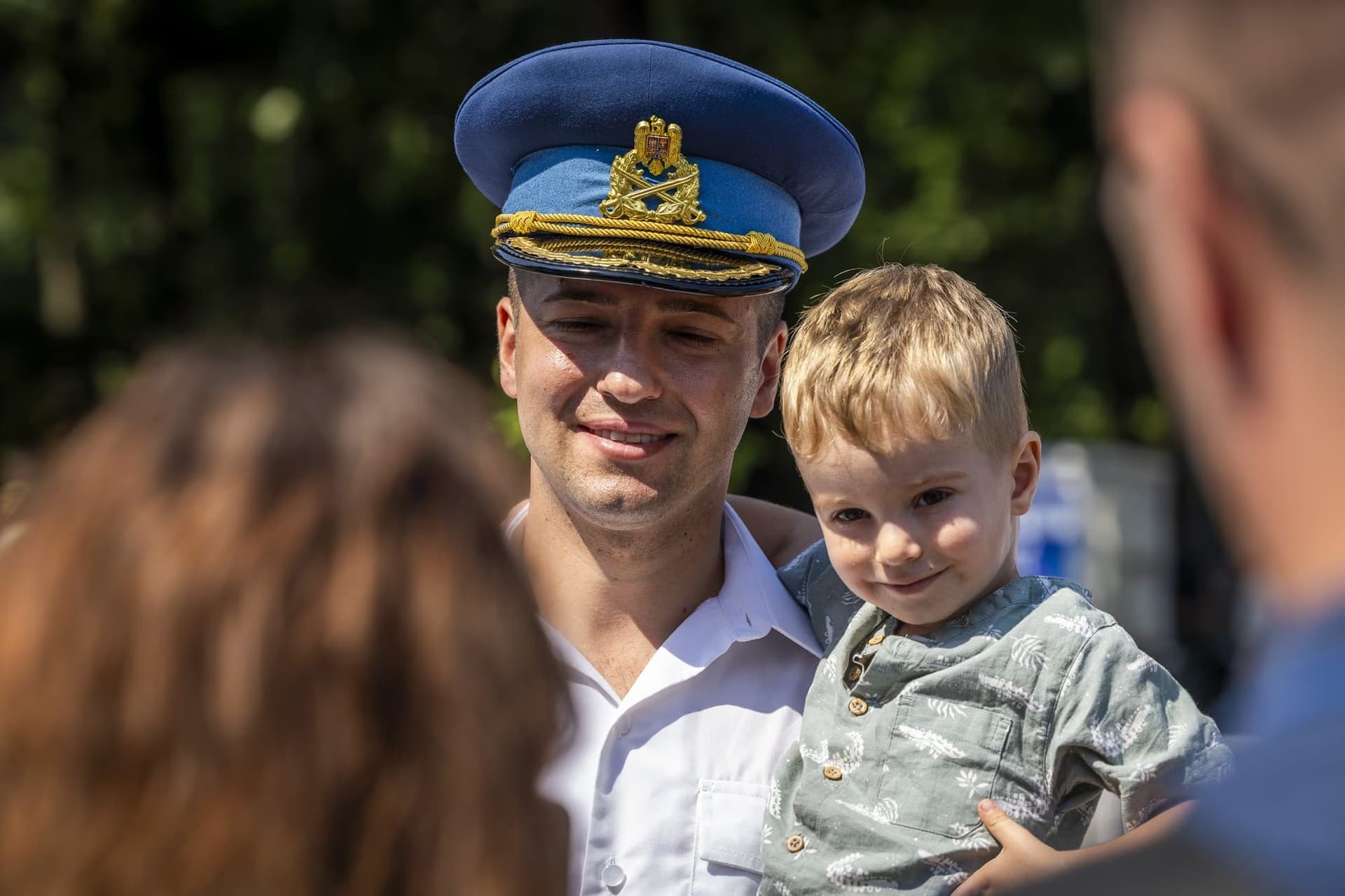 An airman holds his child in the crowd. Photo: AdiCoco.com