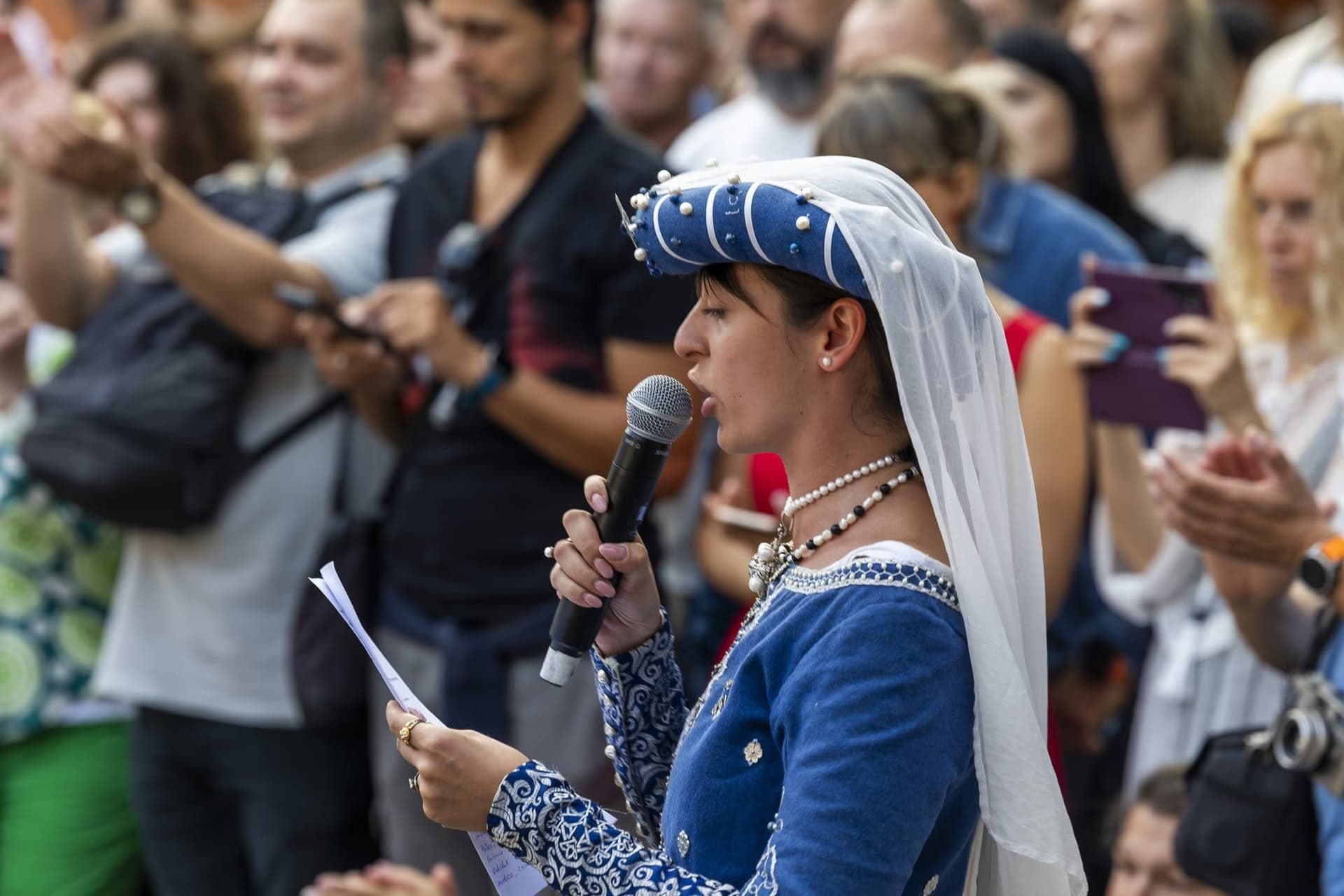 Crainica în costum medieval cu microfon