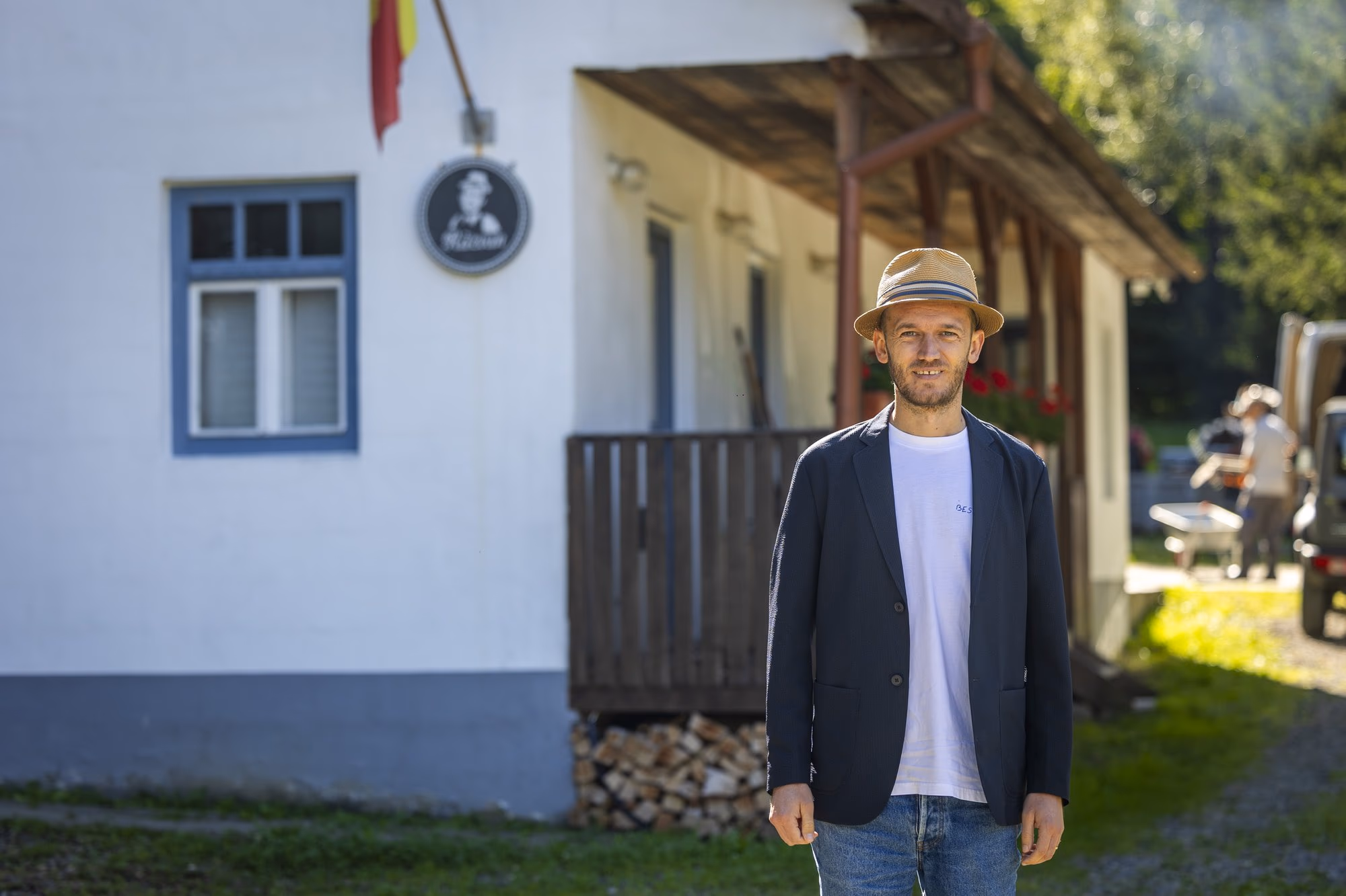 Răzvan Rusu in front of the factory, with the sign and the flag