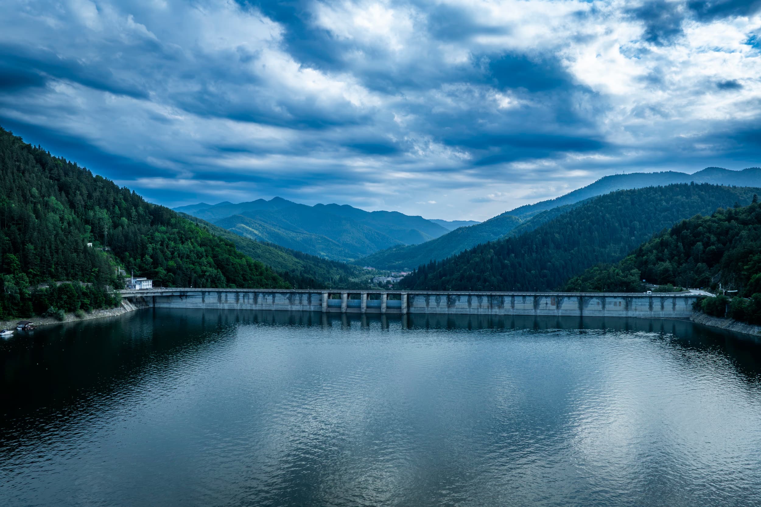 Barajul văzut de pe lac, cu munții în jur