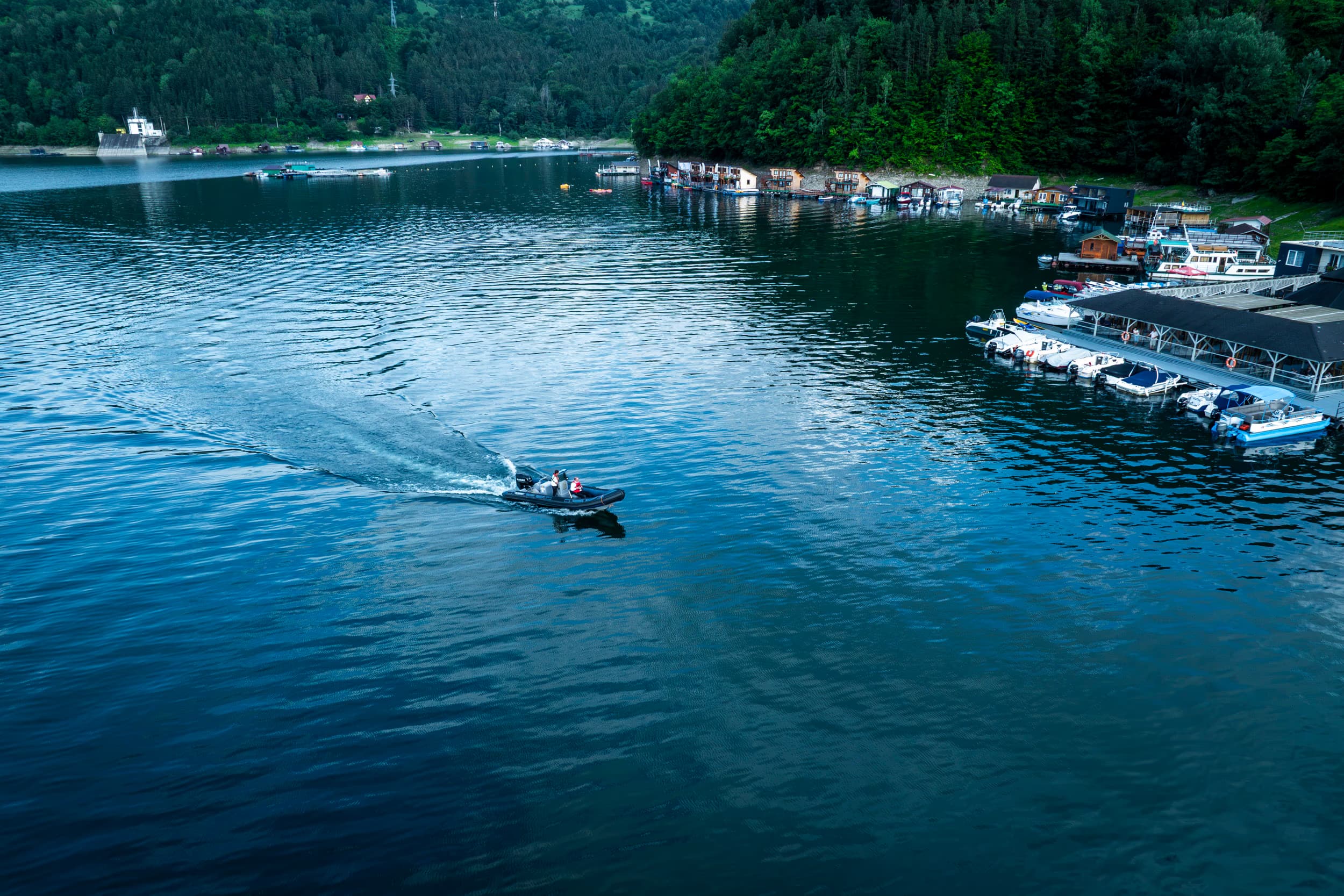 Barcă cu motor lăsând siaj pe lac