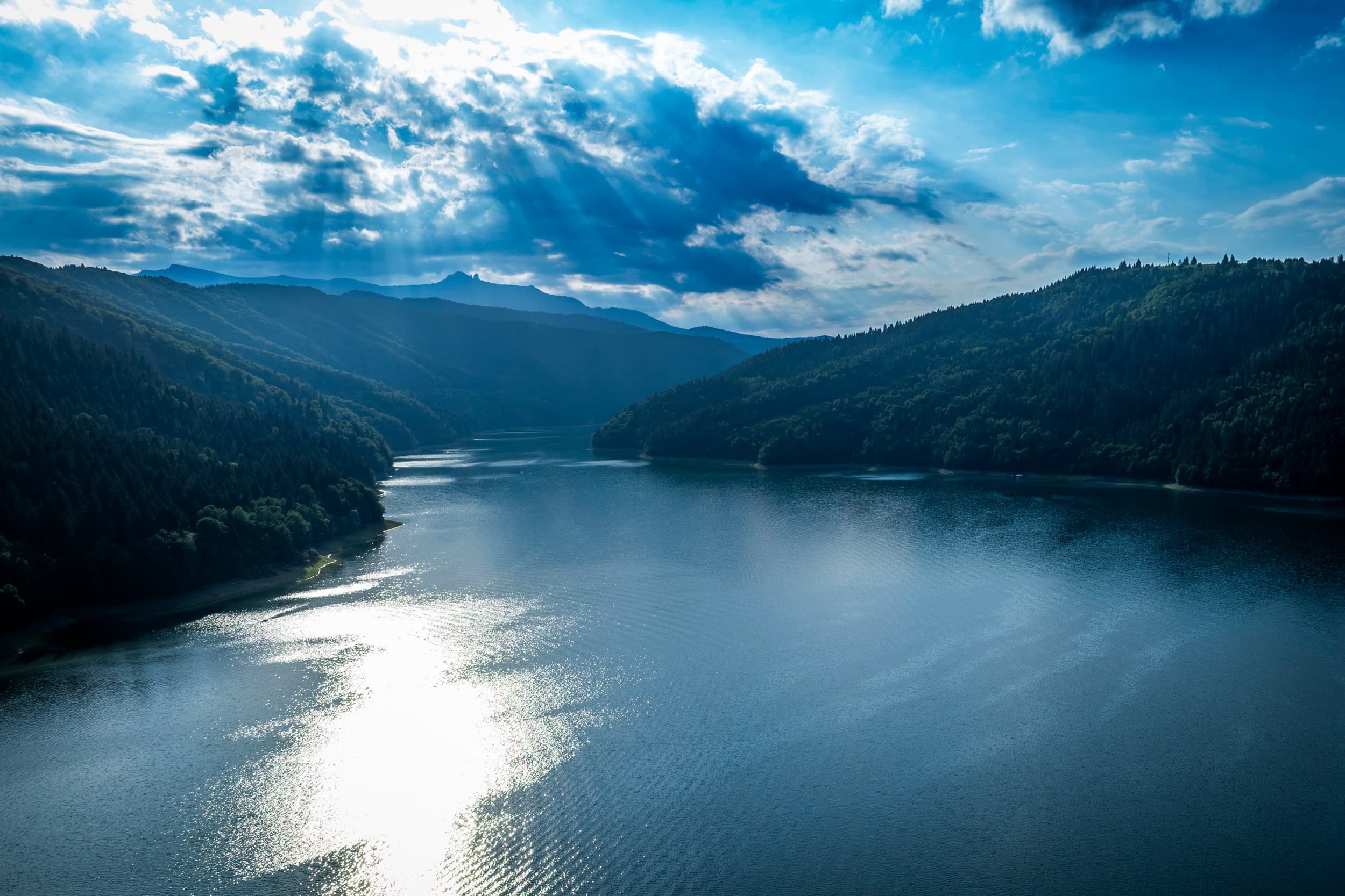 Raze de soare peste lac, printre nori