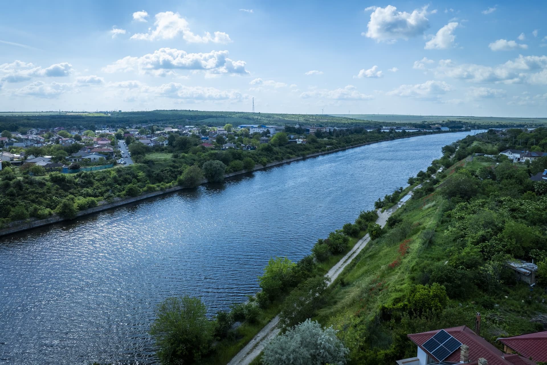 The canal from a drone, with green banks and the town of Murfatlar