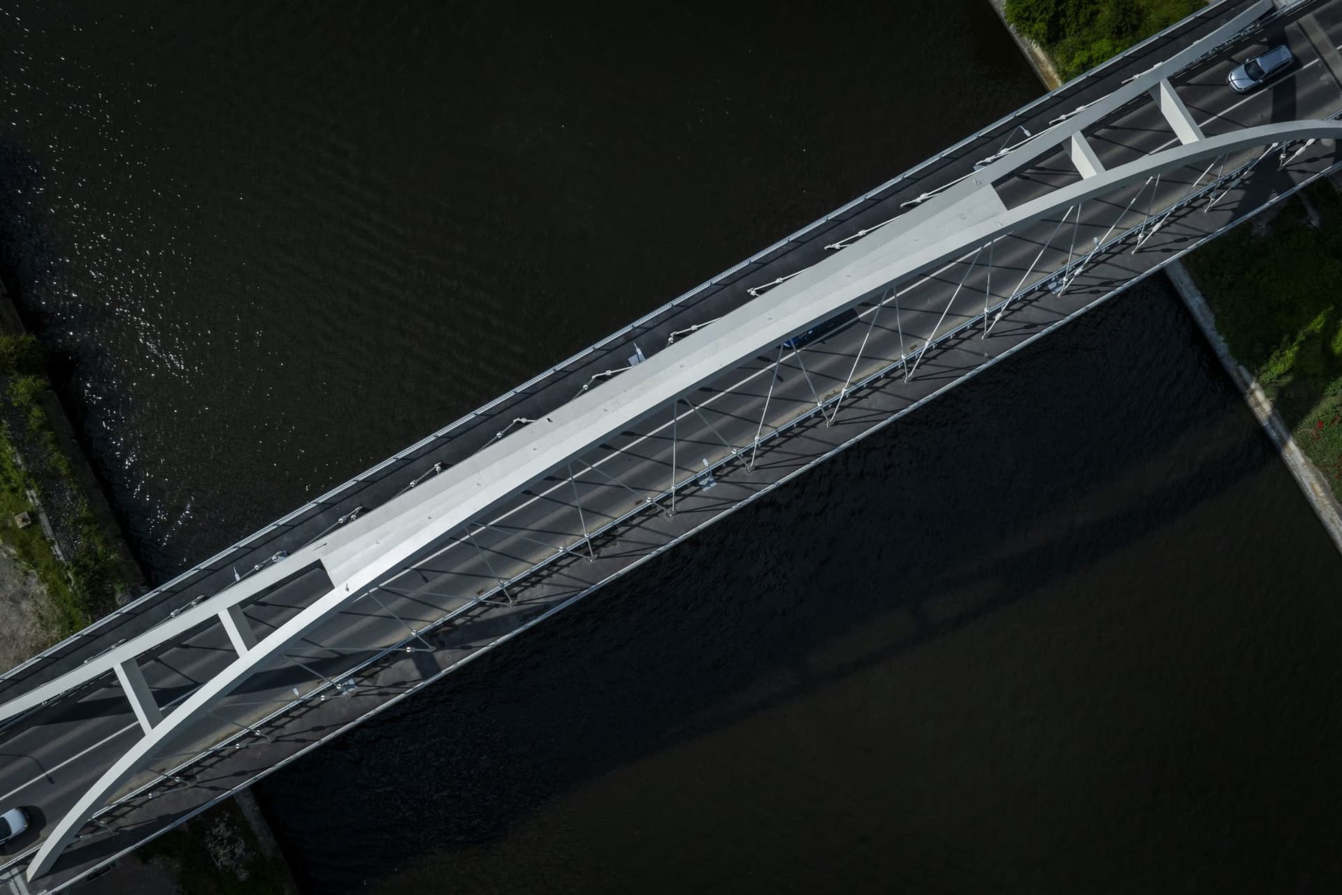 The deck from above, with the arch's shadow cast across the new asphalt