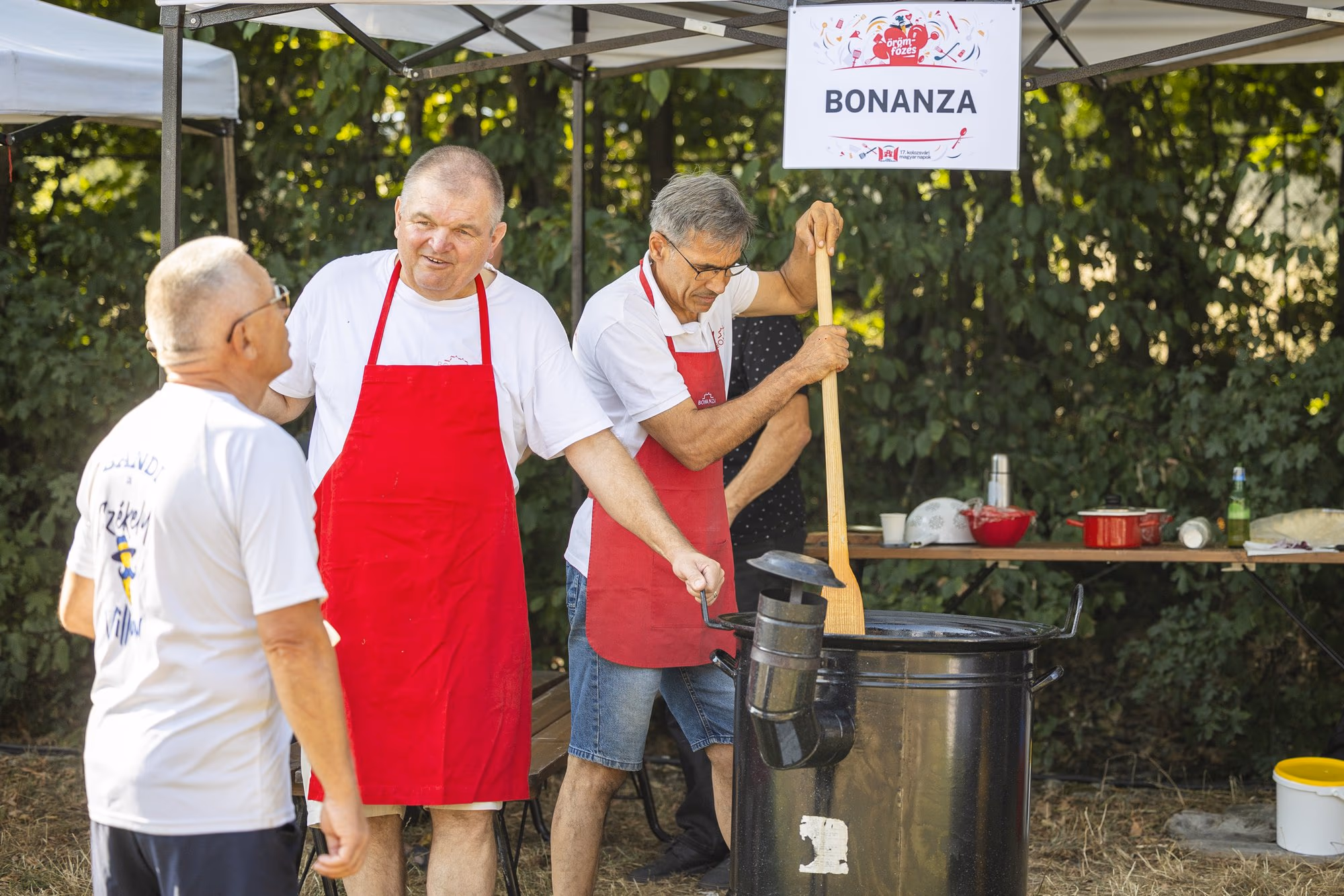 Echipa Bonanza sub firma cortului, amestecând în ceaun