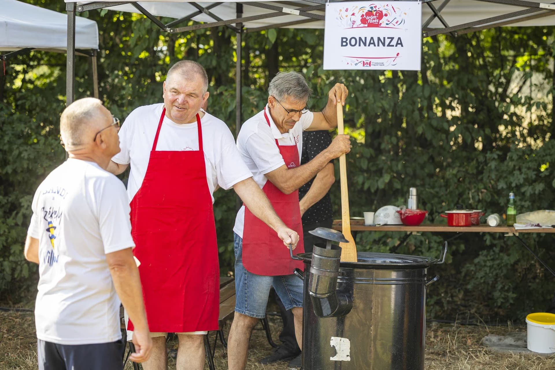 Echipa Bonanza sub firma cortului, amestecând în ceaun