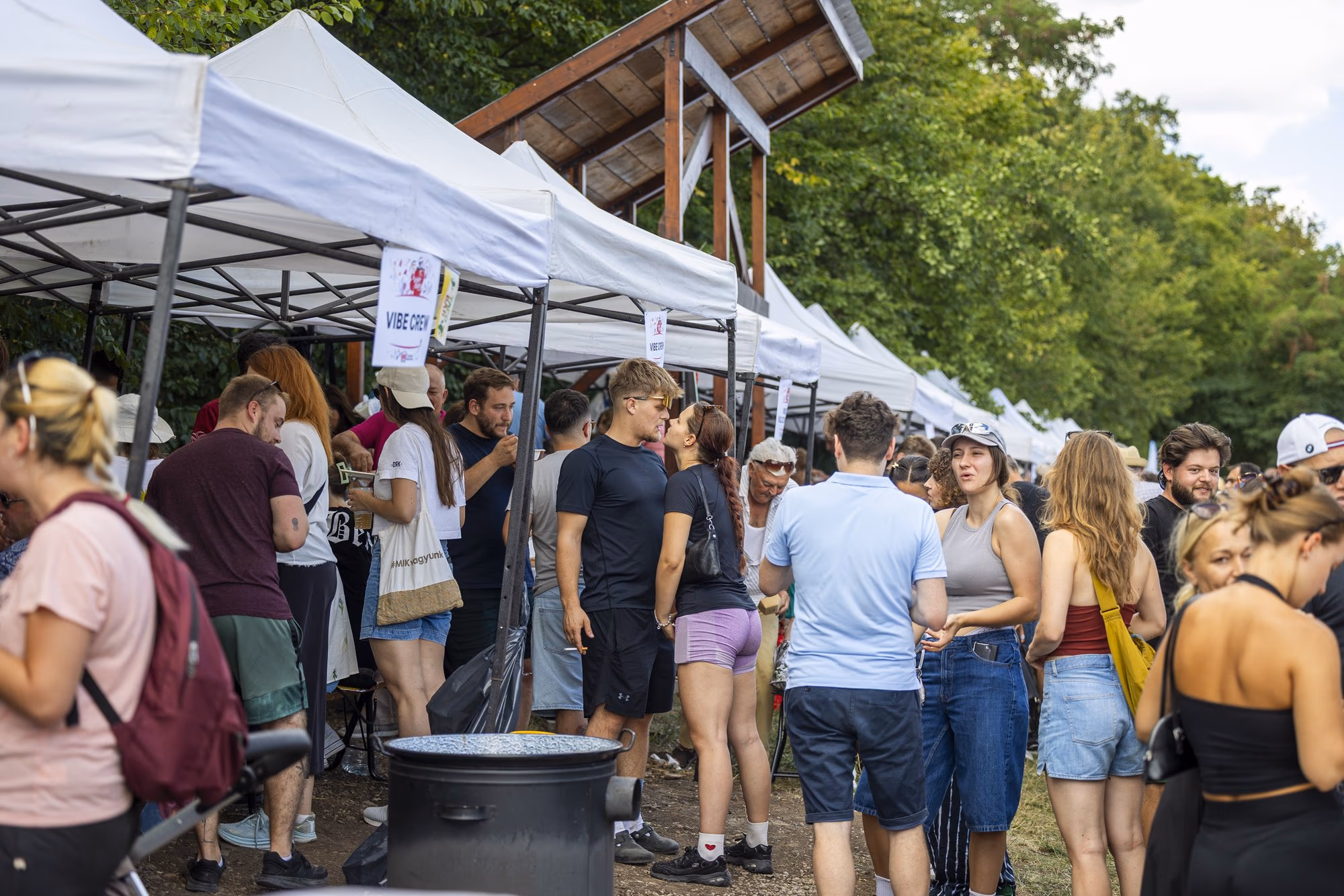 Publicul strâns între corturi, cu farfurii în mână, la sfârșitul zilei de concurs