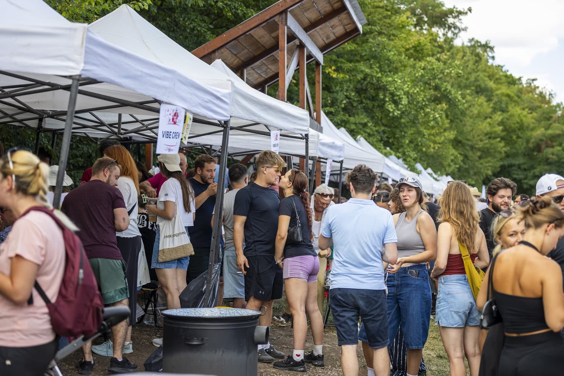 Publicul strâns între corturi, cu farfurii în mână, la sfârșitul zilei de concurs