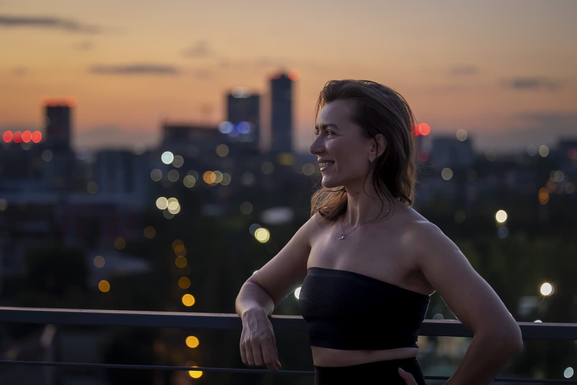 Portret al Ancăi Iftime la apus, cu luminile orașului aprinse în fundal