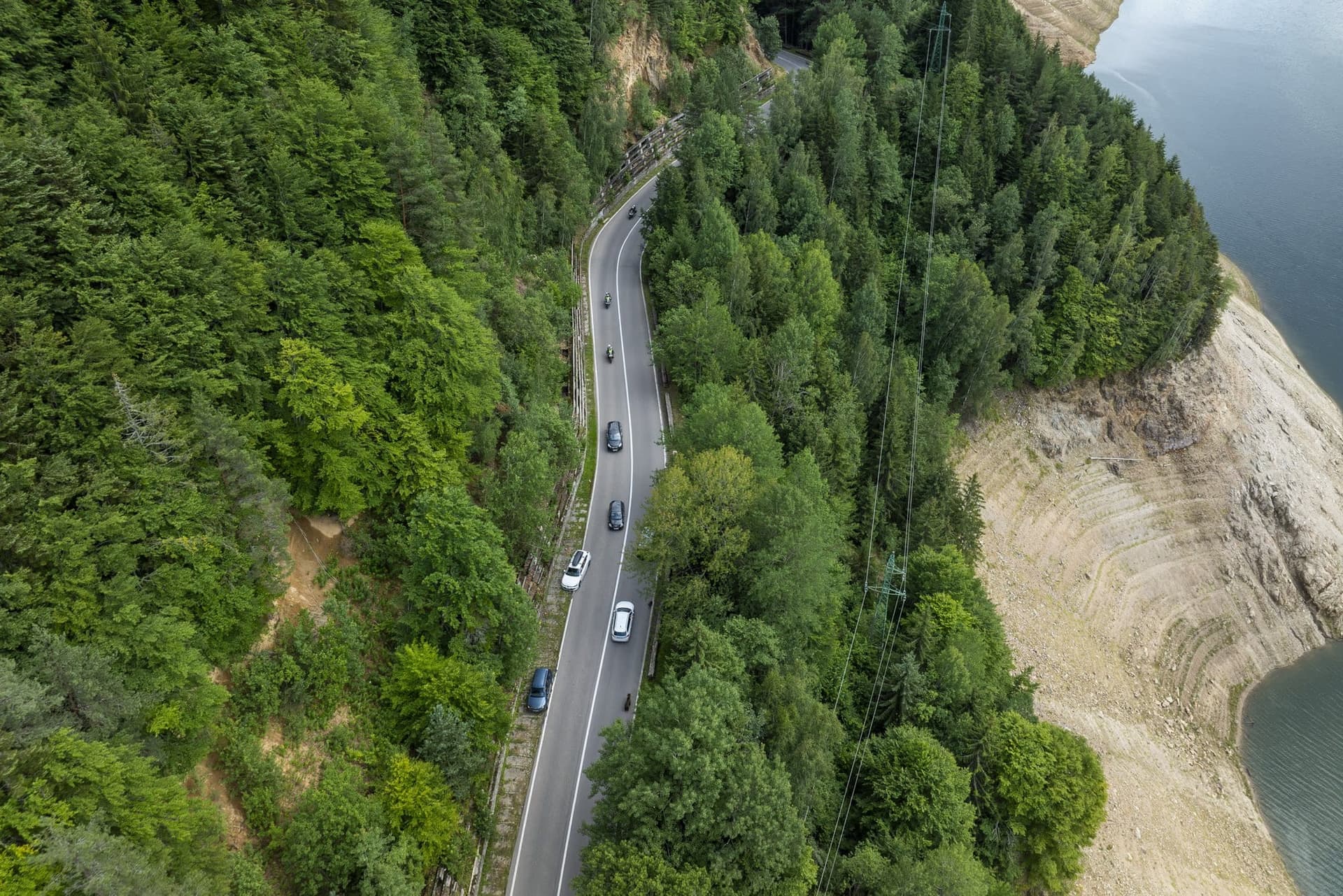 Autók a Transzfogarasi úton, a Vidraru-tó szabaddá vált partja fölött