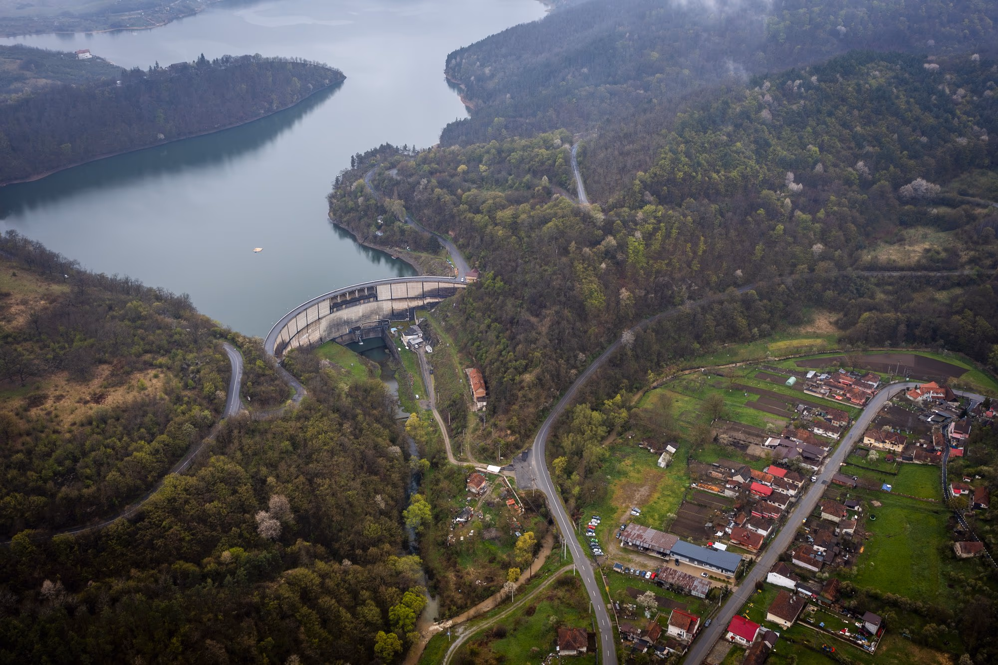 Lake Cinciș with the dam and the village at its foot, in morning mist