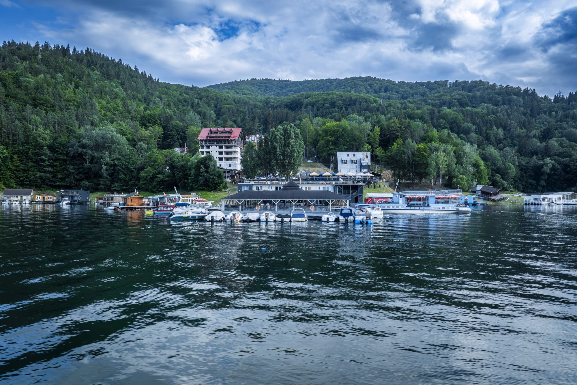 Pontoons and pleasure boats moored on the shore of Lake Bicaz