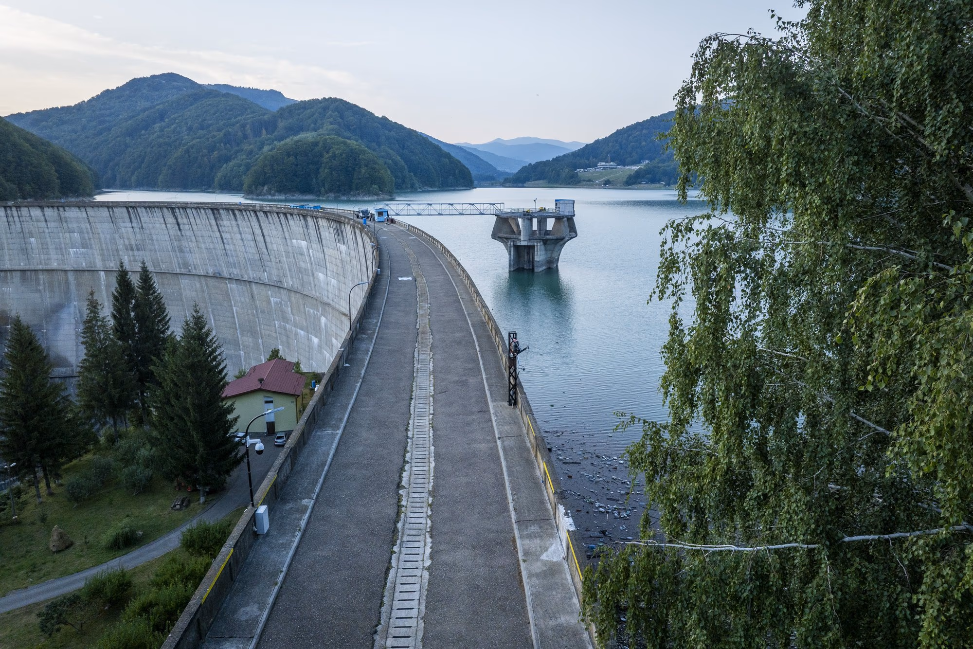 The road along the crest of Paltinu dam and the intake tower rising from the lake