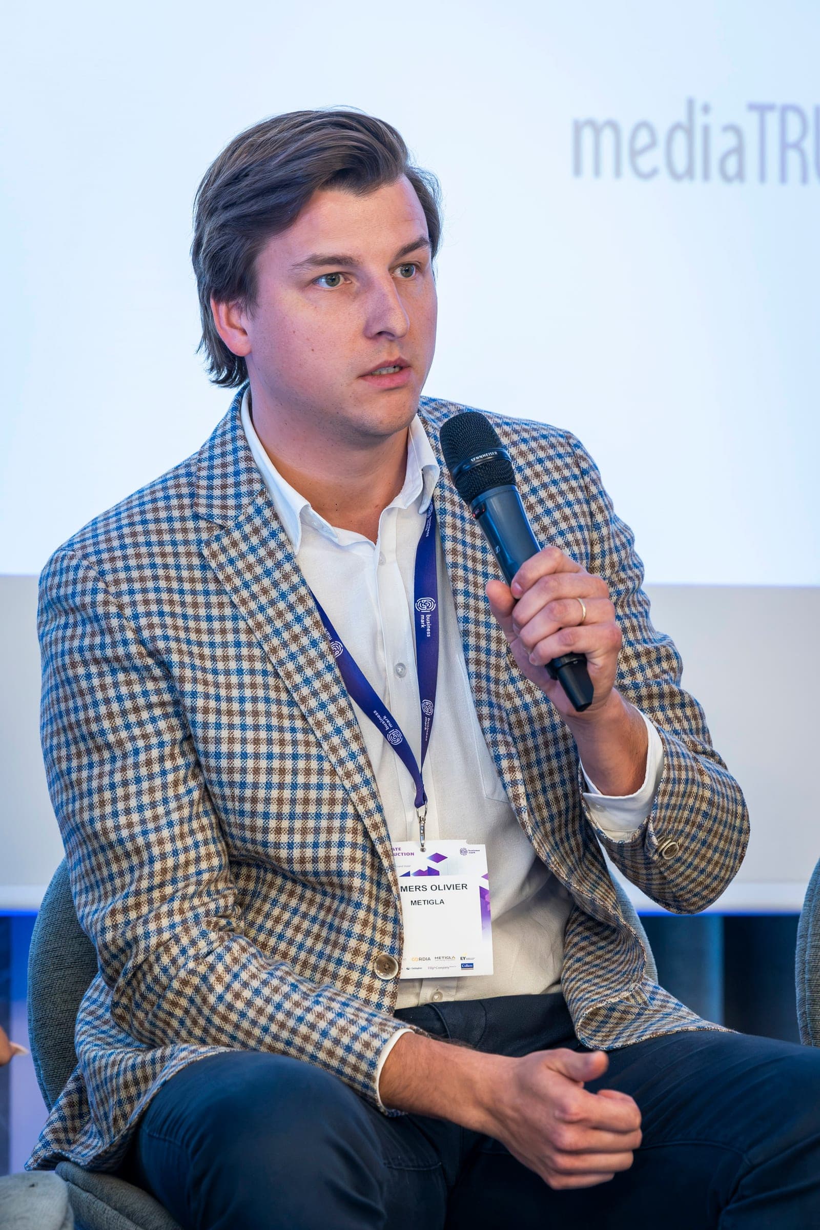 Olivier Somers, in a checked jacket, at the microphone