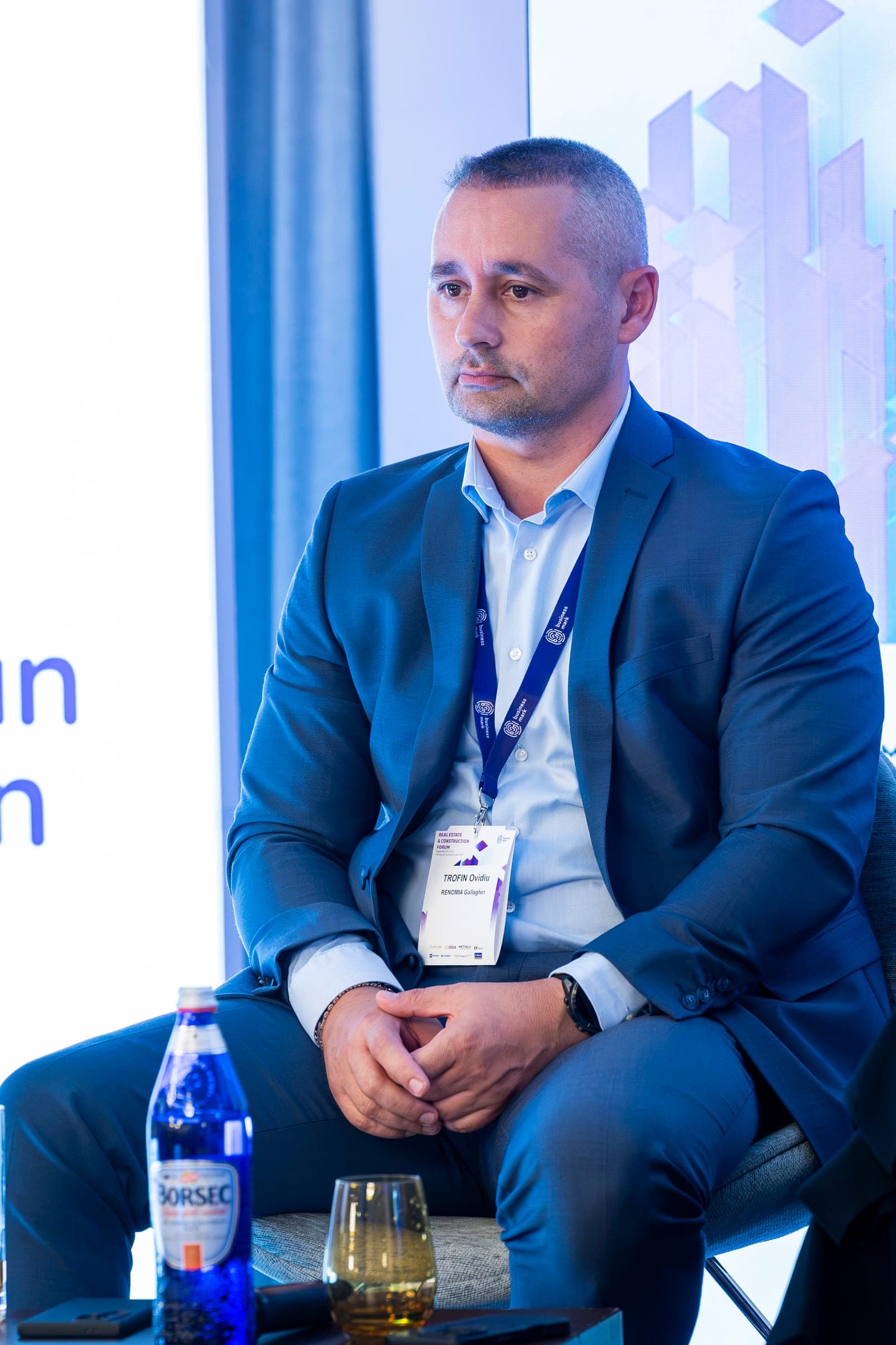 Ovidiu Trofin, in a navy suit, on stage