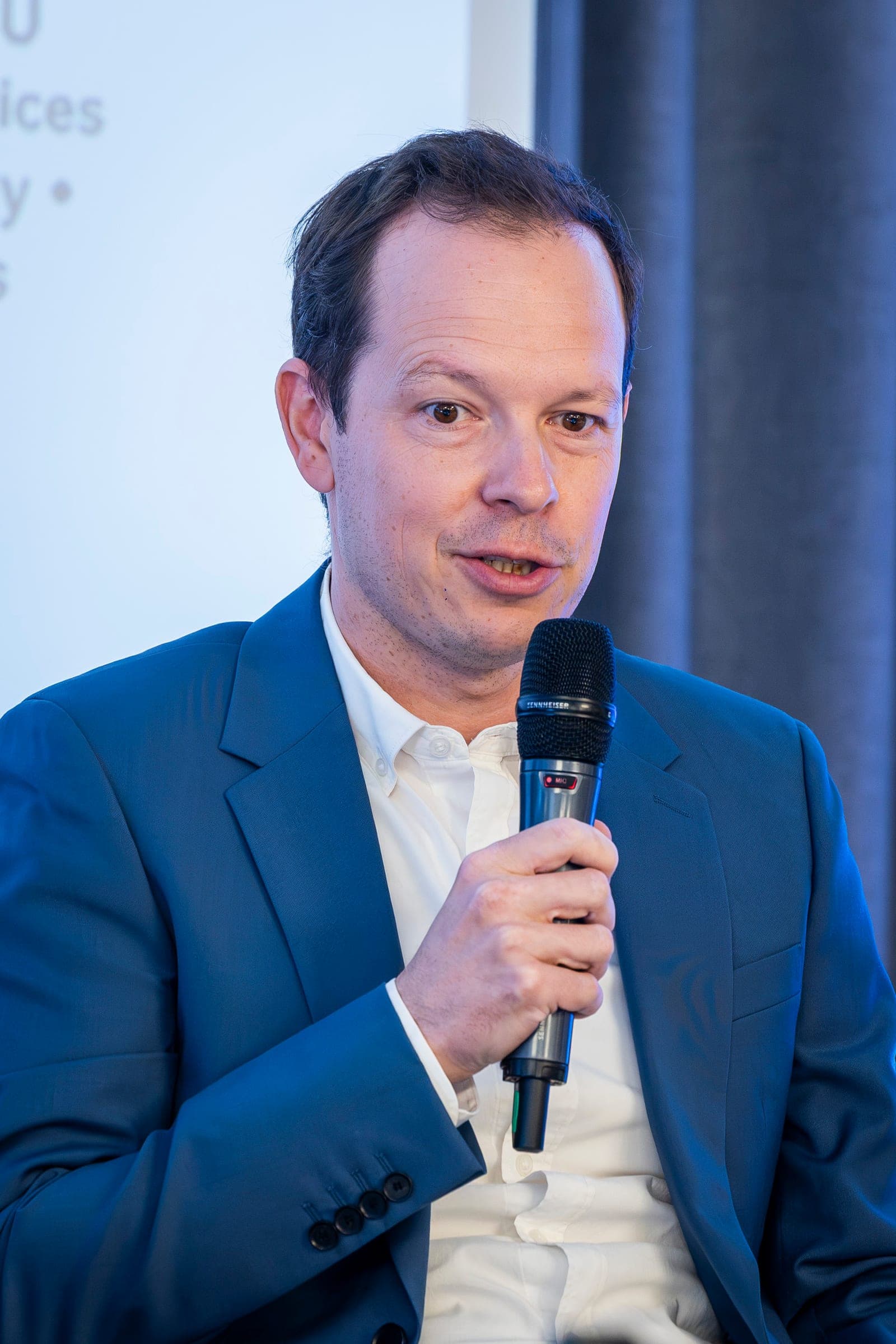 Andrei Boca at the microphone, in a light blue jacket
