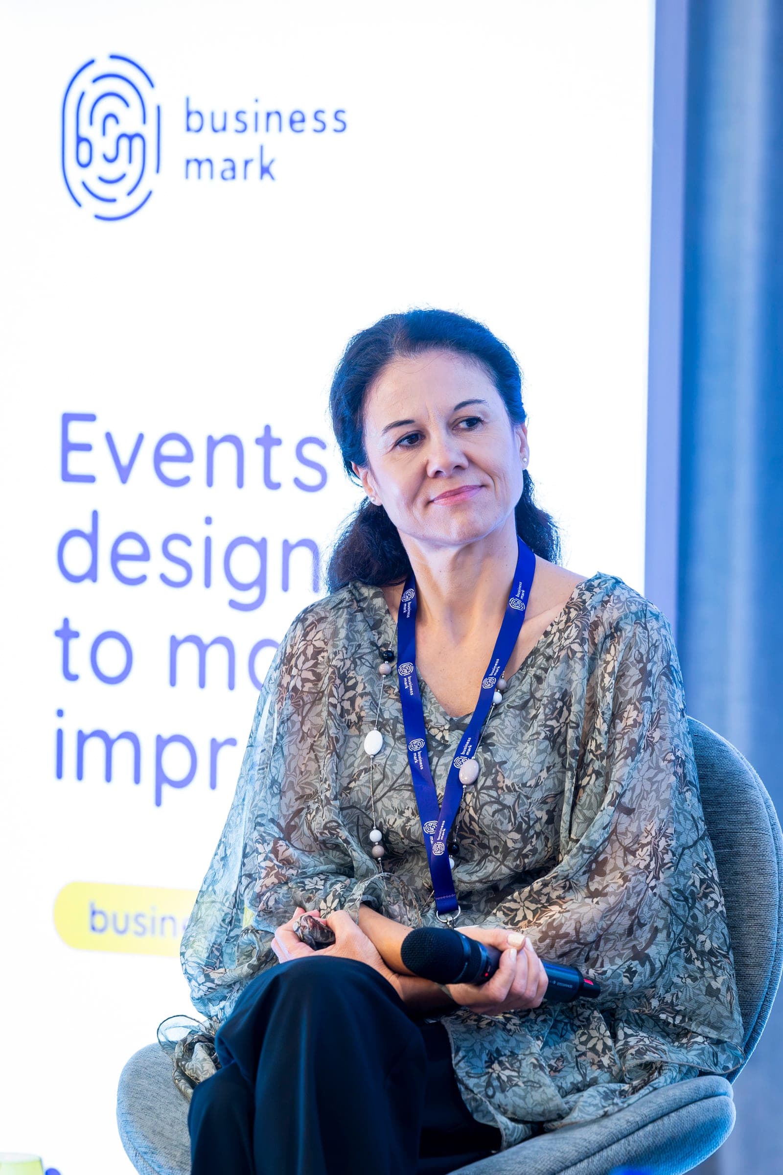 Liana Dumitru a színpadon, figyelve, kezében a mikrofonnal