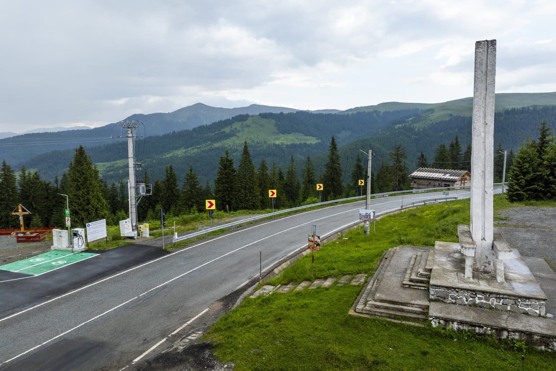 The obelisk at the Prislop Pass beside the DN18, with forested mountains behind