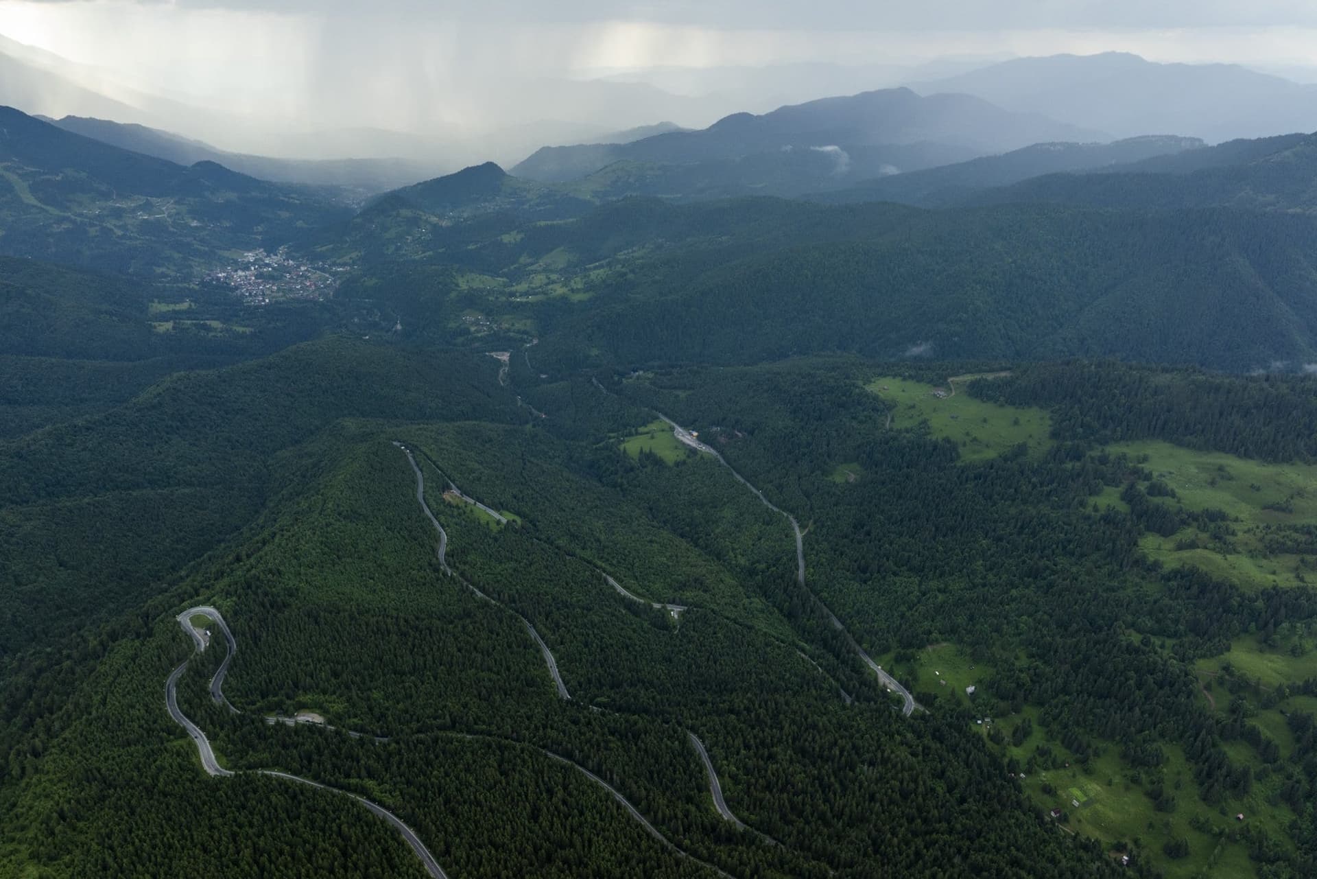 The DN18 hairpins on the forested slope above Borșa, seen from a drone