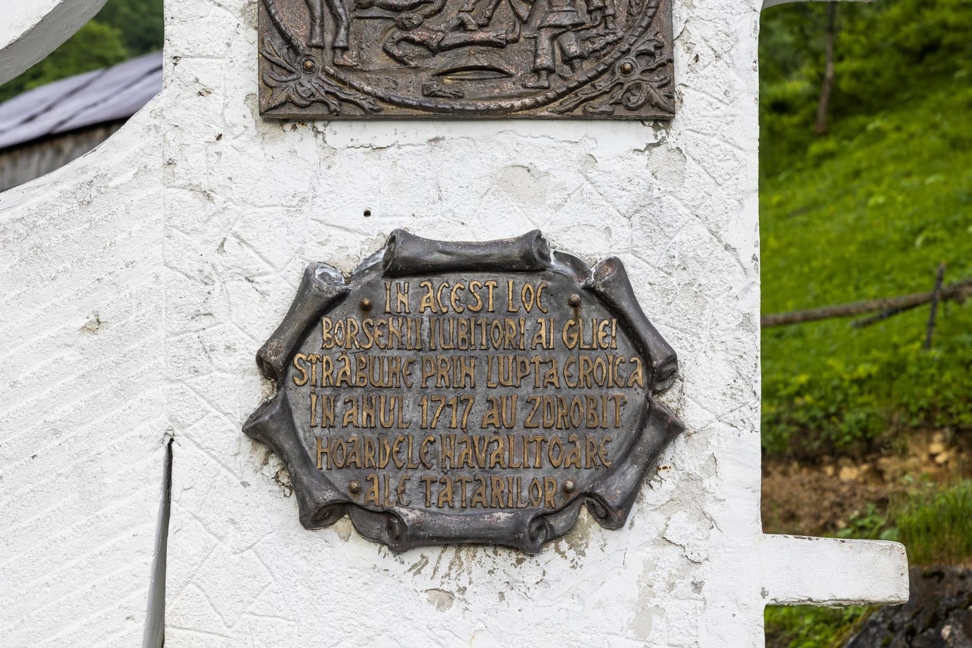 The bronze plaque of the Preluca Tătarilor monument, with its inscription about the battle of 1717, beneath the relief of a battle scene