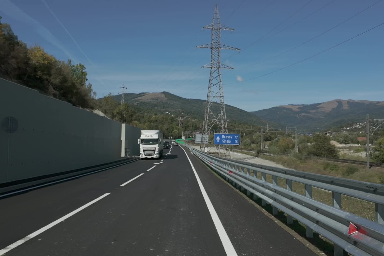 A comarnici elkerülő a támfal mellett, a szemközti sávban egy kamion, jobbra a Brassó és Sinaia felé mutató tábla