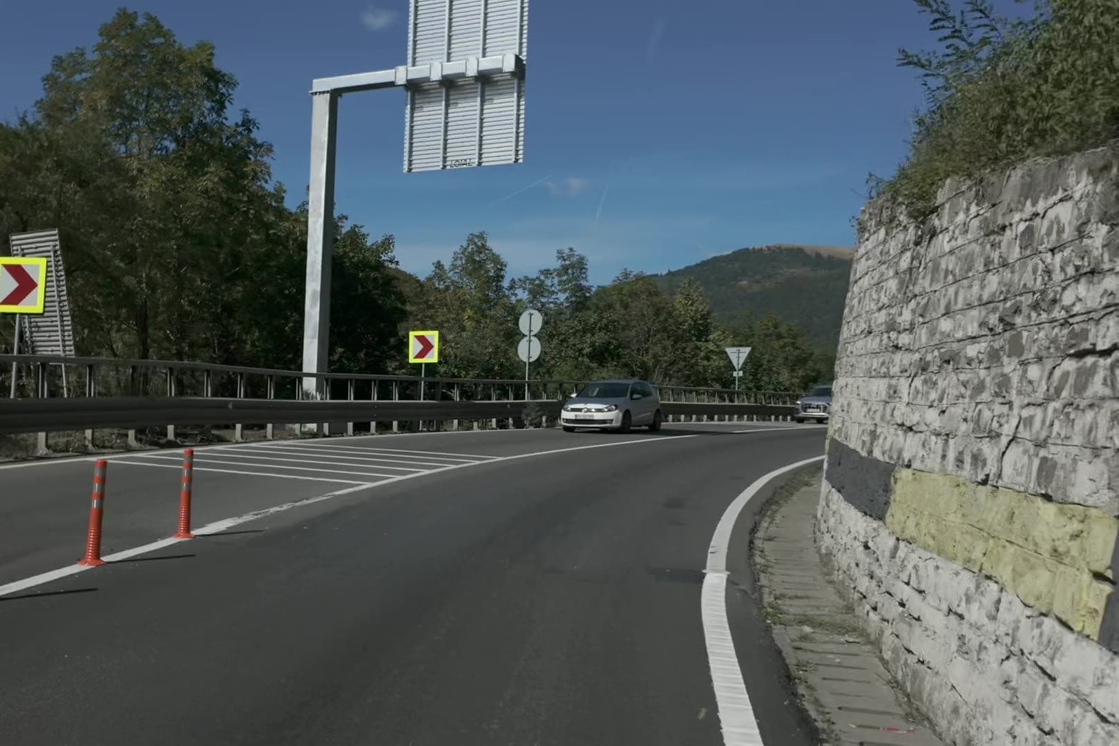 Visszatérés a DN1-re a comarnici elkerülő végén, régi kőfal mellett, előttünk autók