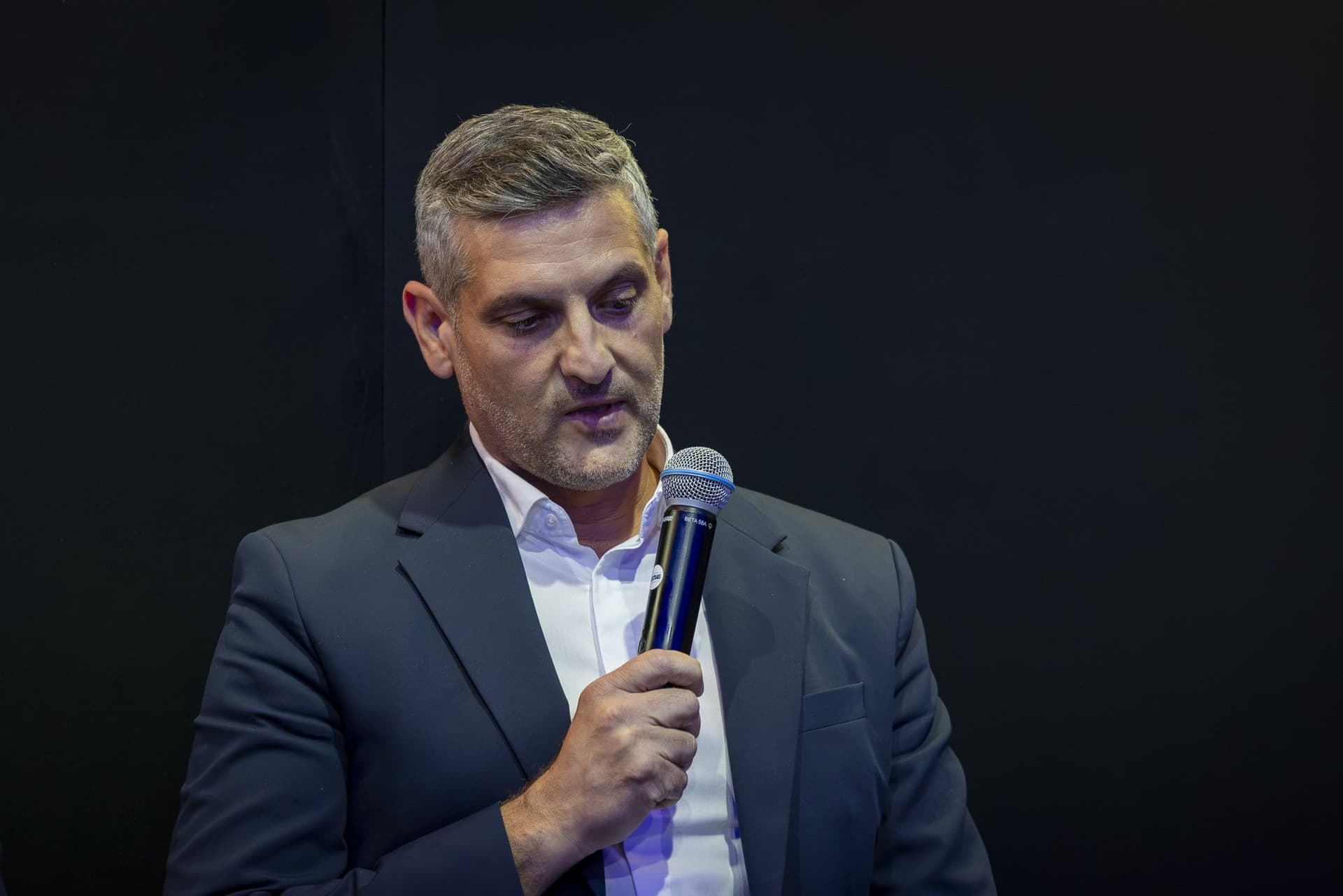 Adrian Mic, a Fortim Trusted Advisors munkatársa mikrofonnal a kezében hallgatja a vitát