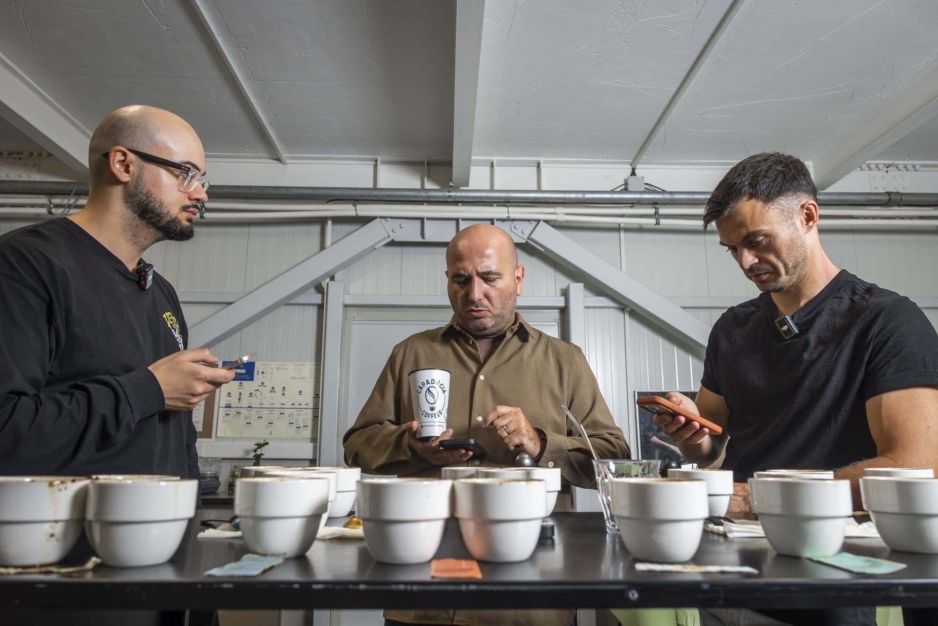 Mihai Panfil gustă cafea între Mihai Grosu și Daniel, la masa de degustare din laborator