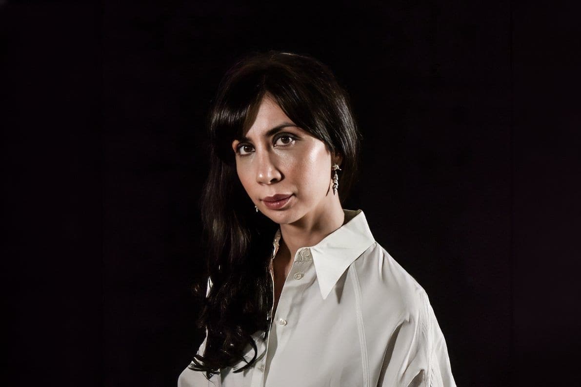 Portrait of Andreea Groenendijk-Deveau in a white shirt against a black background