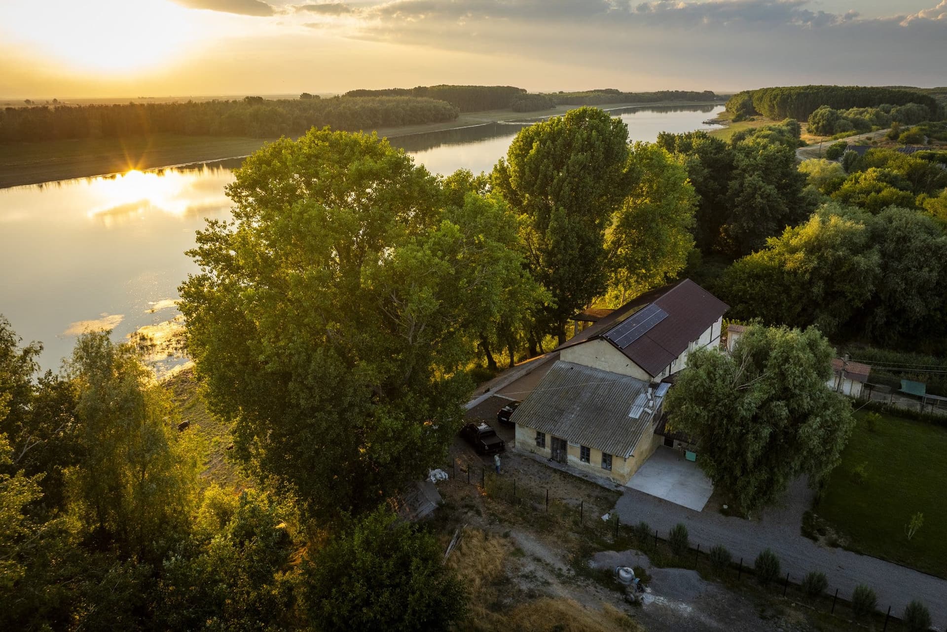 Sunset over the Măcin branch, with the high bank and the building on it